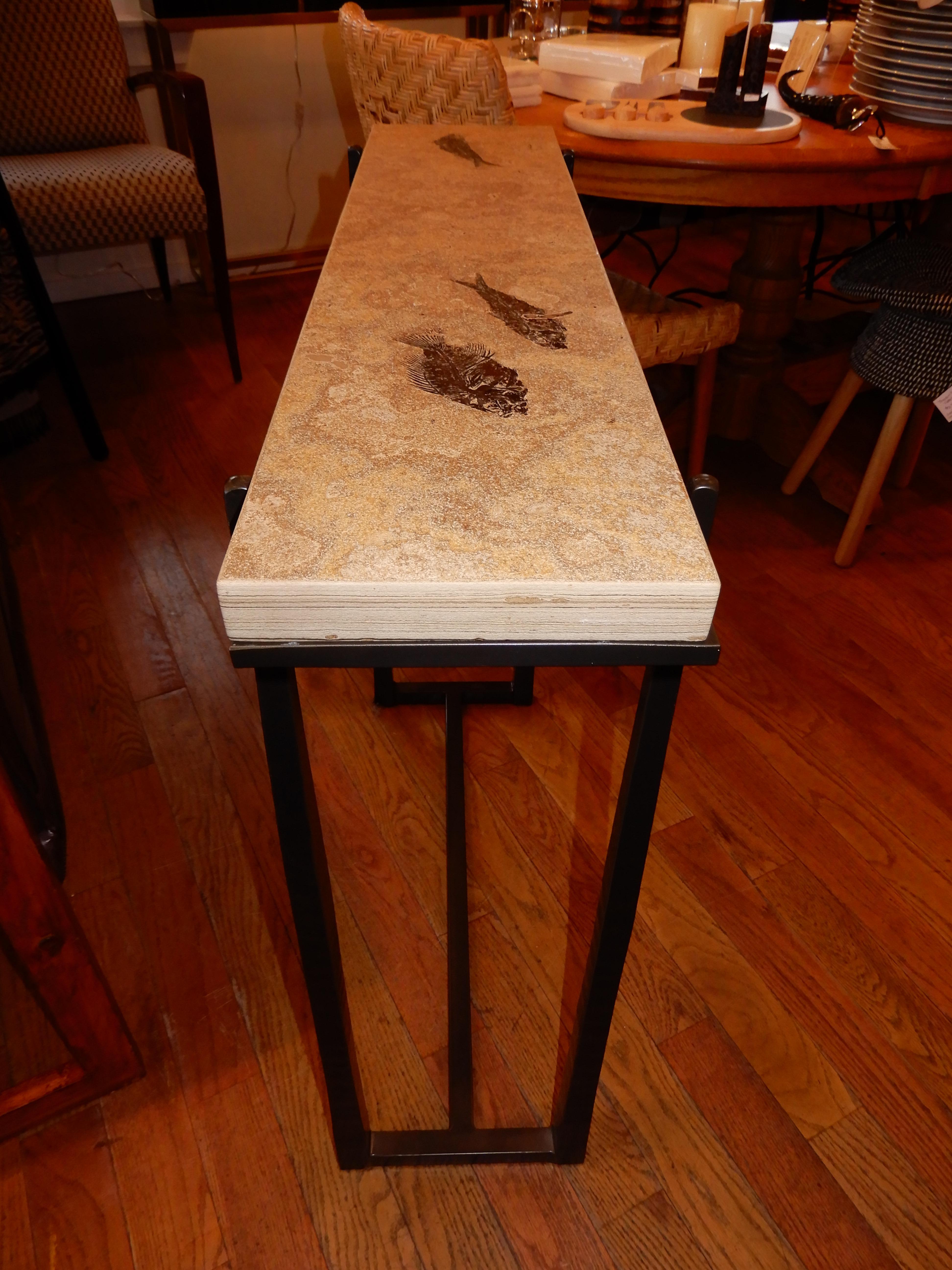 A rare and one of a kind console table, handcrafted with ancient fossils (Priscacara liops & 2- Knightia eoceana) set in natural honed stone and sealed to protect from stains. Hard to believe that something 50 million years old can be preserved and