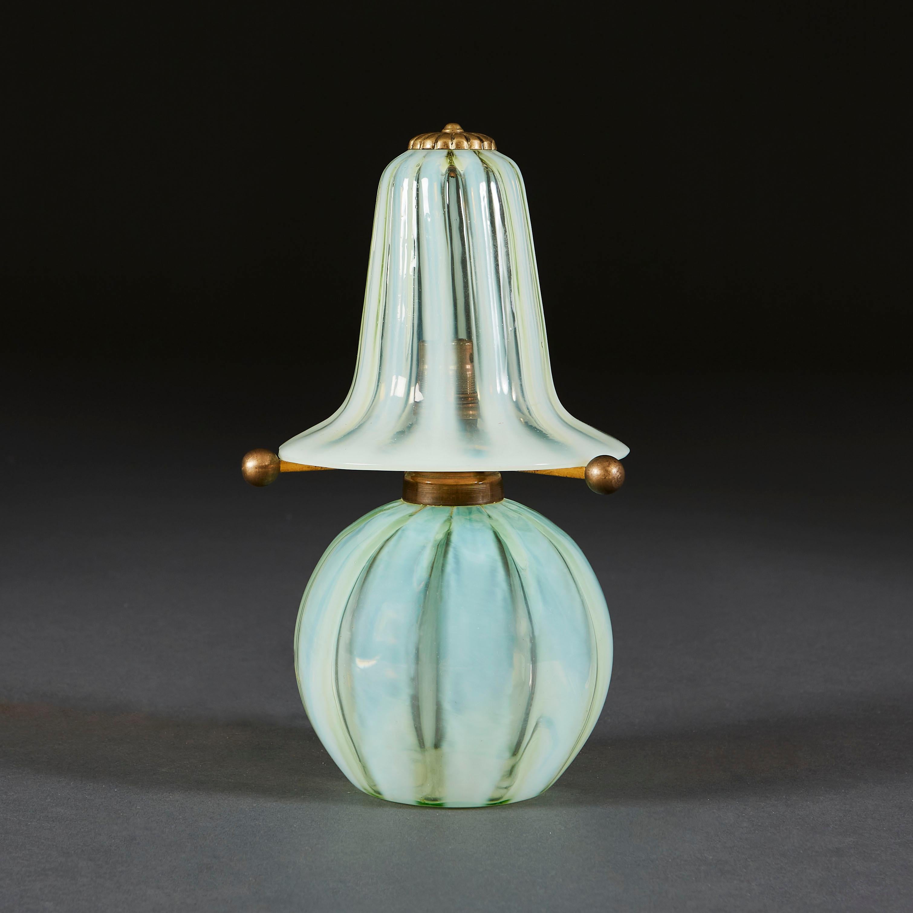 A rare, small opaline glass lamp with a glass shade, all decorated with green and clear glass vertical stripes. The shade supported by three brass arms terminating in brass spheres.

Currently wired for the UK.