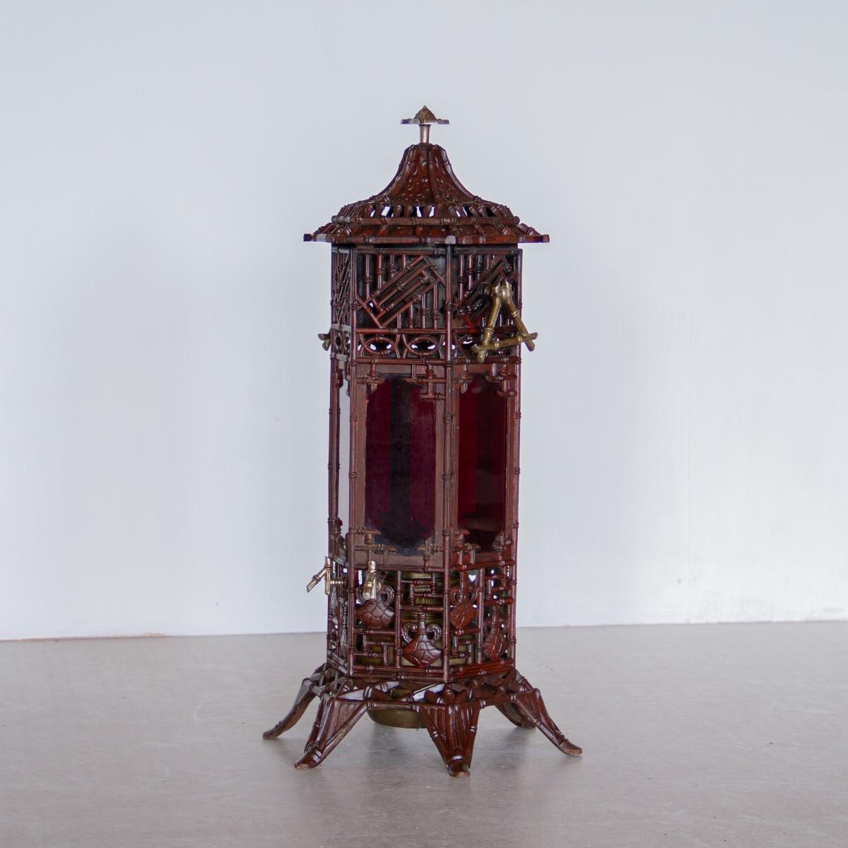 A rare ornate French cast iron conservatory heater in truly original condition with stained red panels. The panels are decorated with cast urns and bamboo and painted in a deep burgundy with accents of brass, set on 6 pierced iron legs. circa