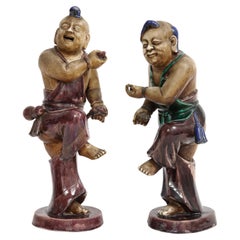 Paire rare de figurines de garçon en porcelaine biscuit Kangxi avec décorations en émail