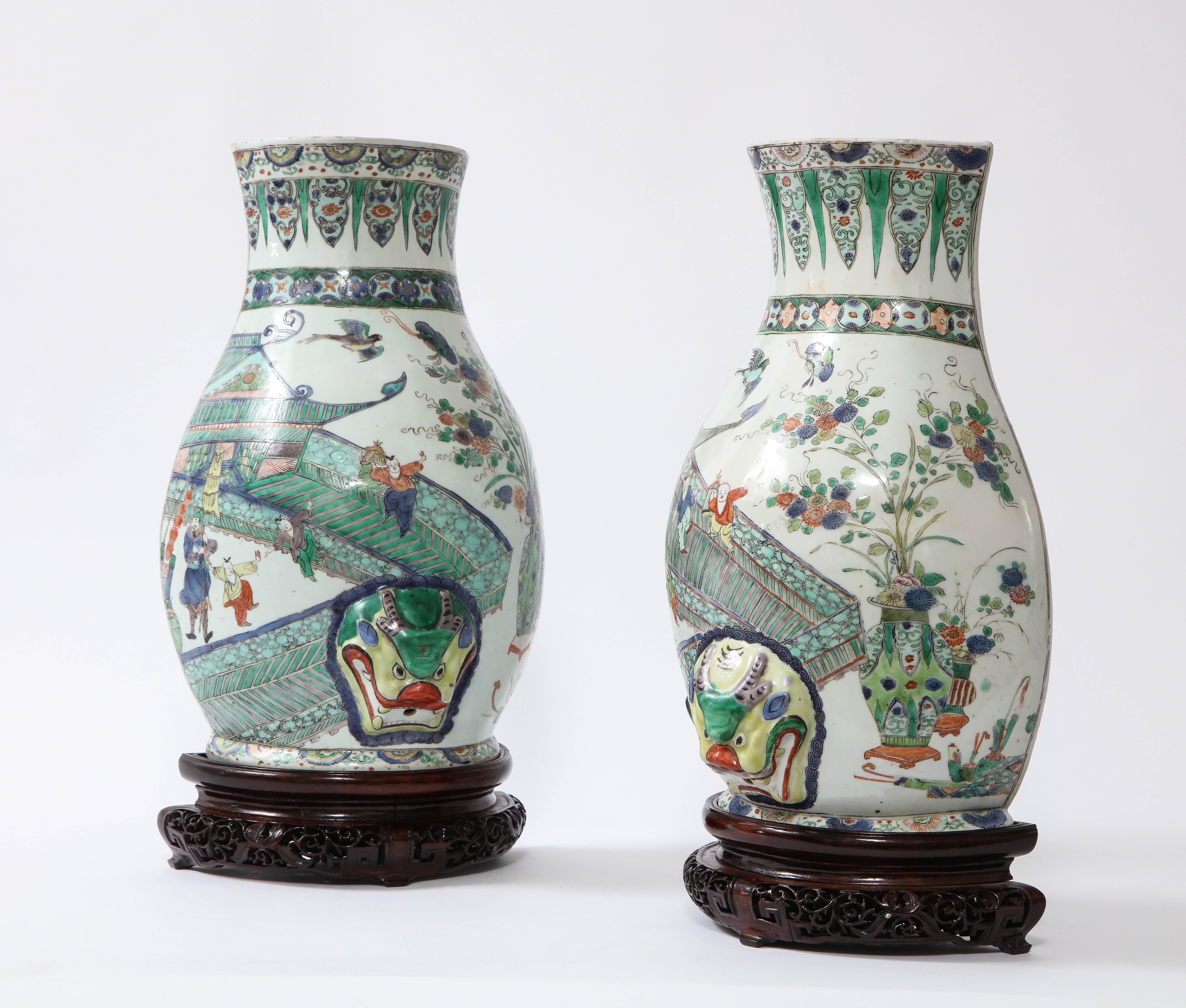 A Fantastic and Rare Pair of Kangxi Period (18th Century) Chinese Porcelain Wucai Decorated Wall Vases/Fountains.  Of pear shape, brightly enameled with three court ladies conversing on a terrace, observed by a courtier, the background depicting