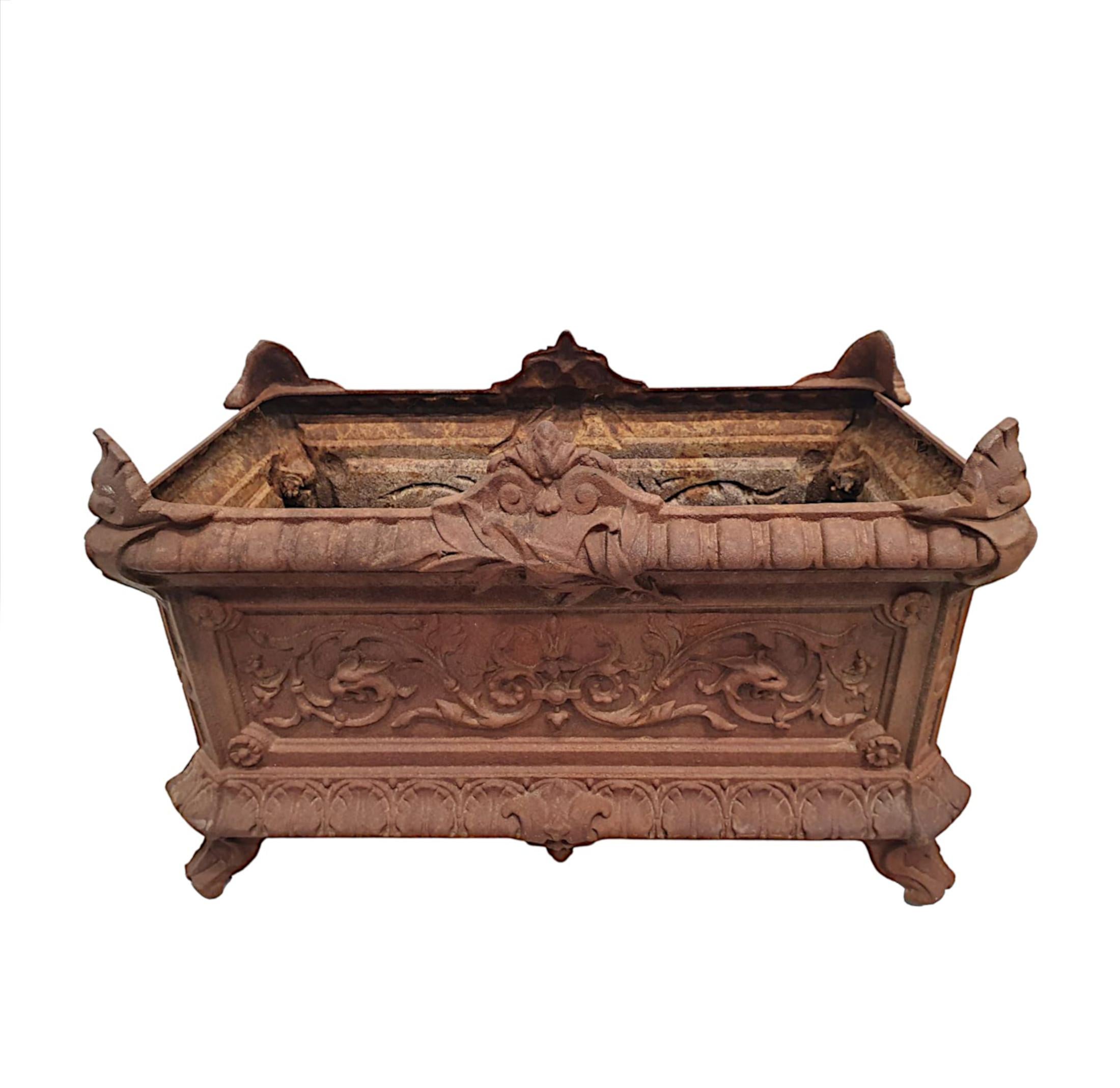 Raro par de jardineras de hierro fundido del siglo XIX, de forma rectangular con esquinas inclinadas, rematadas con bellos motivos foliados, volutas y conchas estilizadas.  Sobre un borde evertido con detalles de gallones, encima de un cuerpo