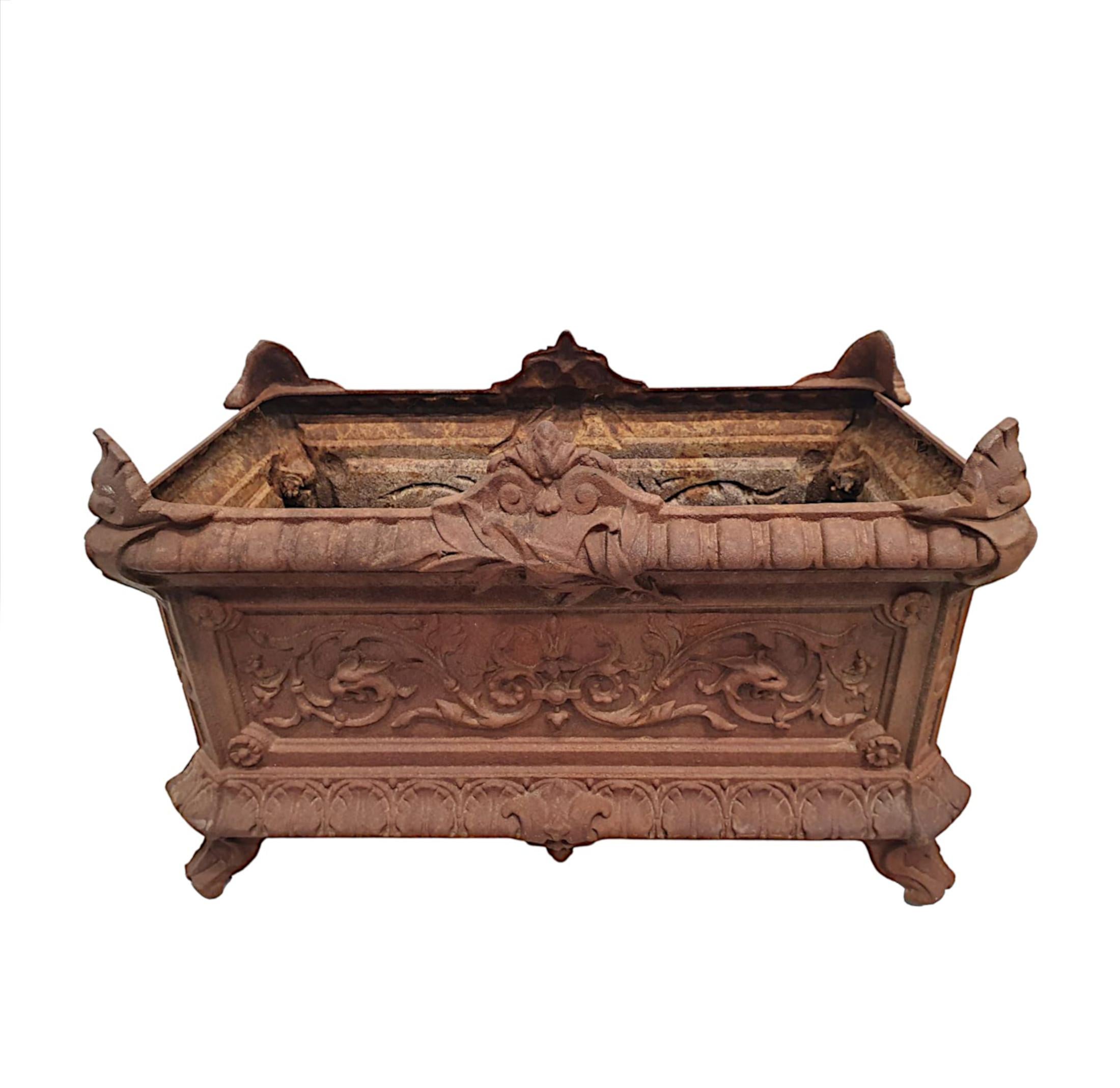 A rare pair of 19th Century cast iron garden planters of rectangular form with canted corners, surmounted with beautiful foliate, scroll and stylised shell motifs. Raised over everted rim with gadroon detail above panelled body with centred plaques