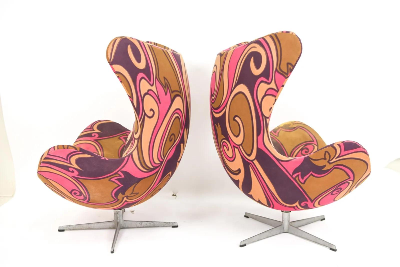A rare pair of Arne Jacobsen for Fritz Hansen swivel Egg chairs and matching ottoman. Having its original mid century upholstery and resting on aluminum bases. Each piece having original labels on underside.  

Condition: The chairs and ottoman were