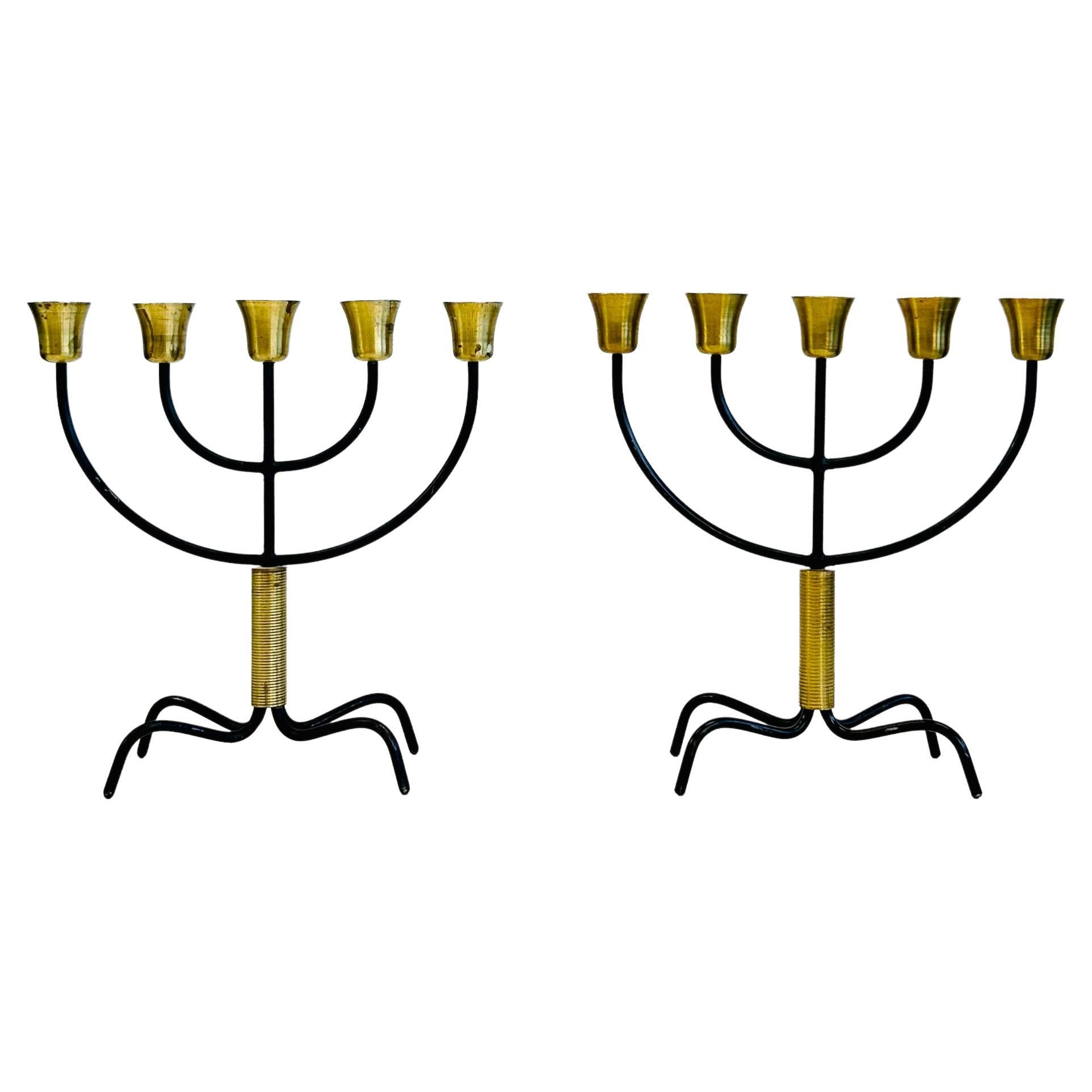 A pair of stunning 5-candle candelabras by the iconic Svend Aage Holm Sørensen. These rare pieces, featuring a beautiful black metal and brass construction, are in very good vintage condition. One of the candelabras boasts the 'Holm Sorensen'