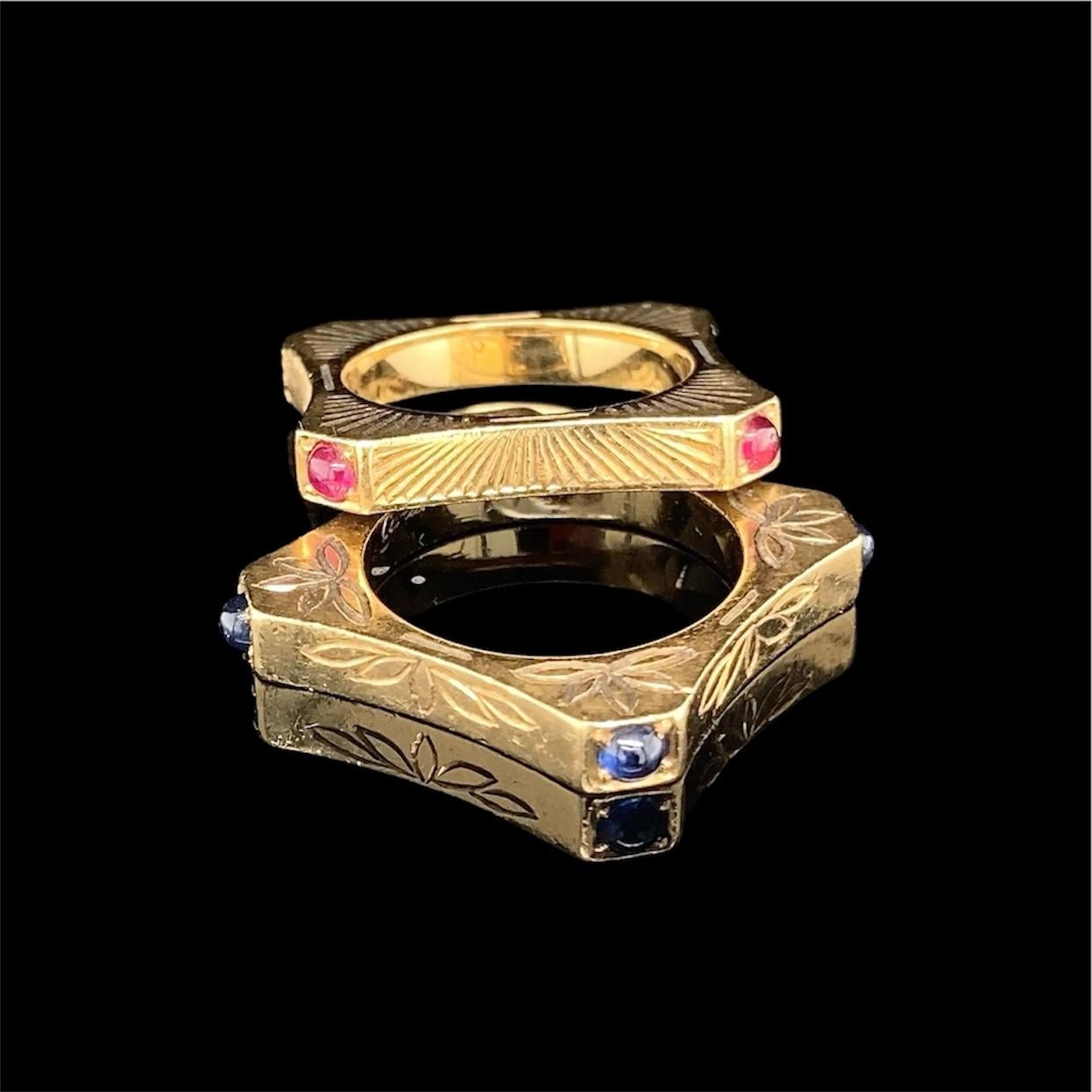 Coppia di anelli con zaffiro e rubino cabochon inciso di Cartier in oro 18 carati, anni '40/'50 circa.

Ciascun anello di forma quadrata con lati concavi, gli angoli impreziositi rispettivamente da zaffiri e rubini cabochon; i lati incisi con