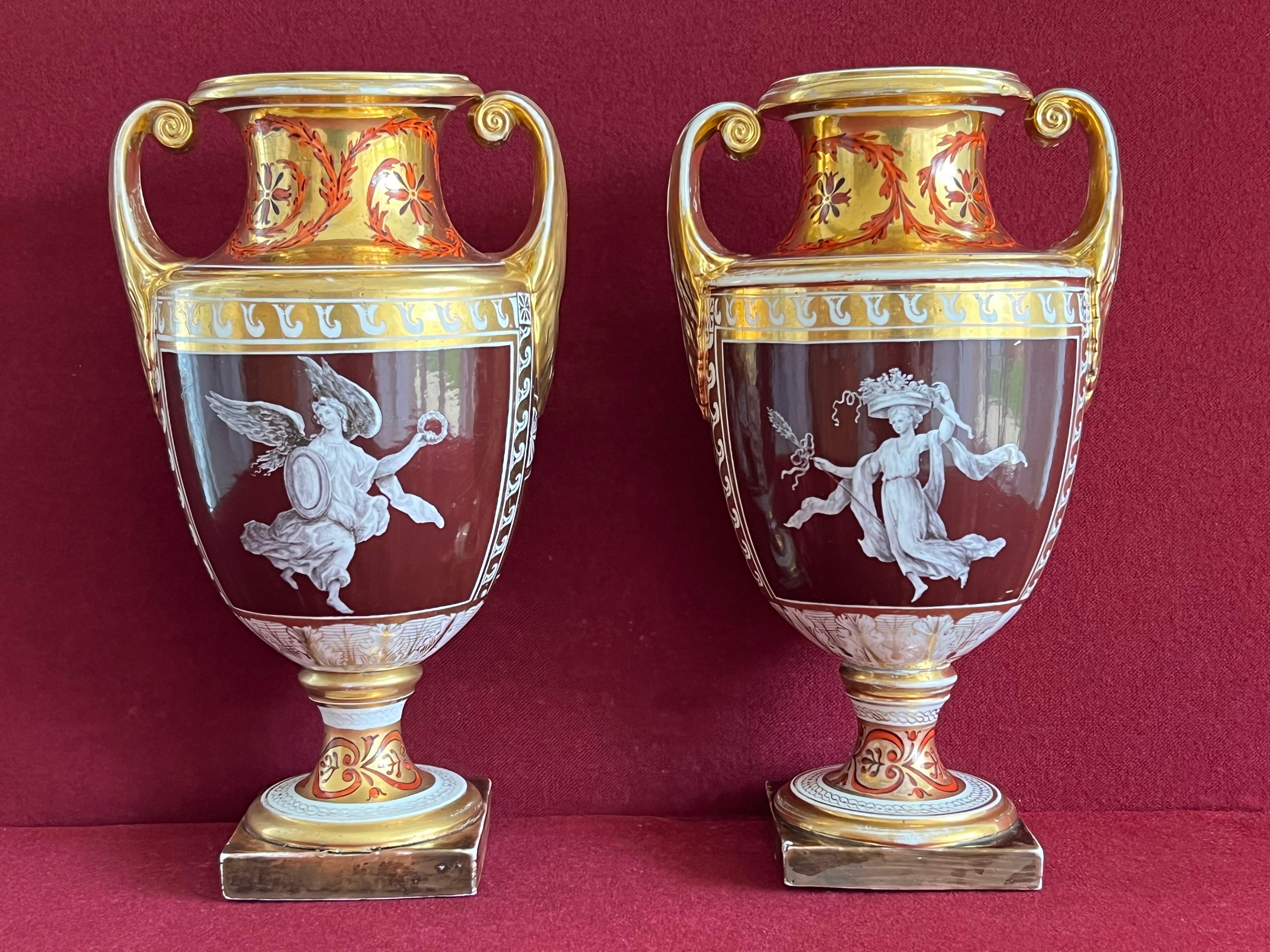 A rare pair of Coalport porcelain vases c.1802-1805. Each vase of slender classical form with scrolled handles, painted in London by Thomas Baxter ‘en grisaille’ with classical figures, reserved on a deep chocolate ground with panels of classical