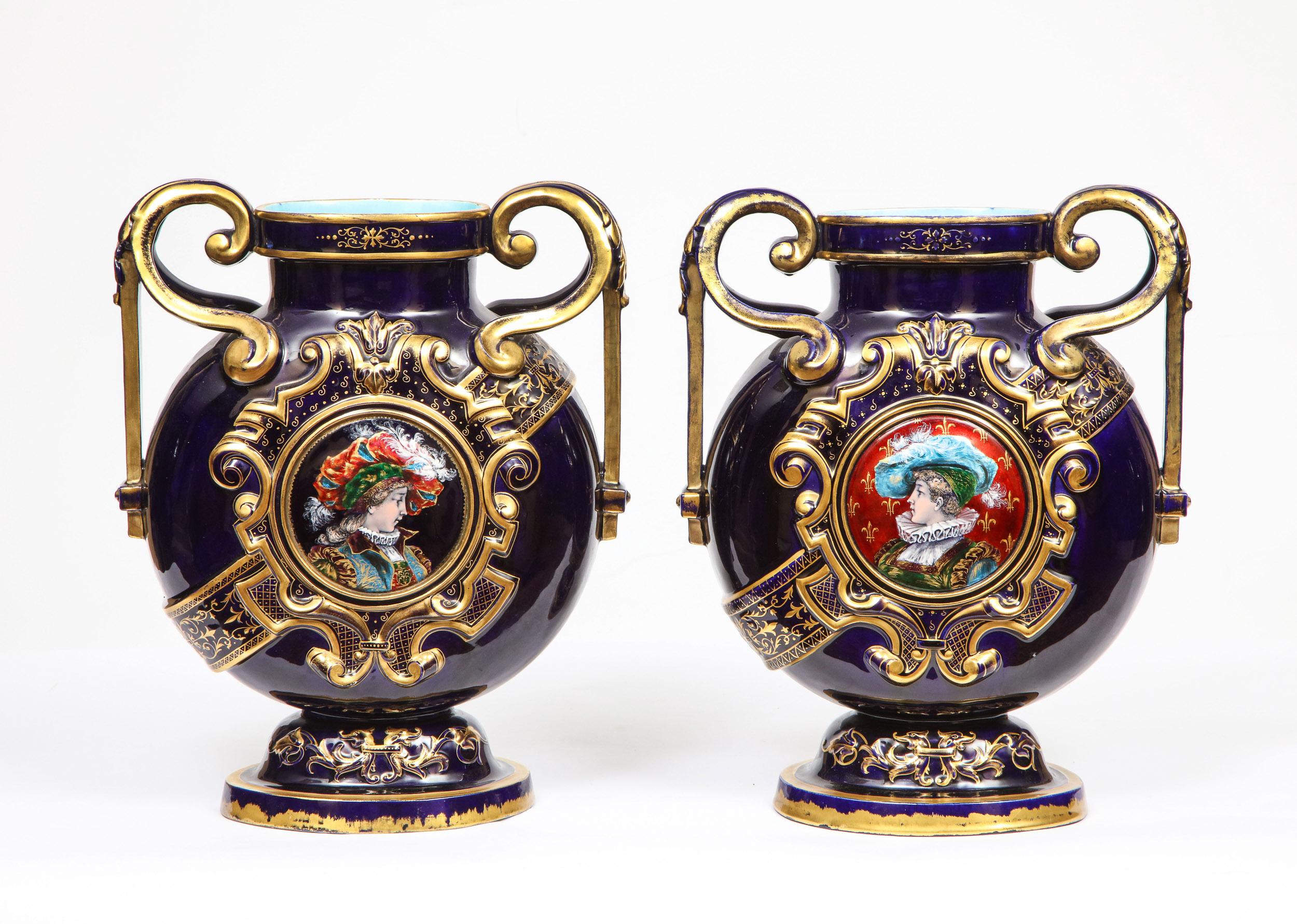 A rare pair of Emile Galle cobalt blue porcelain and Limoges enamel portrait vases.
France, late 19th century.

Elaborately gilded to a deep cobalt ground with gilt highlights throughout, with central Limoges enamel roundel medallions to each

