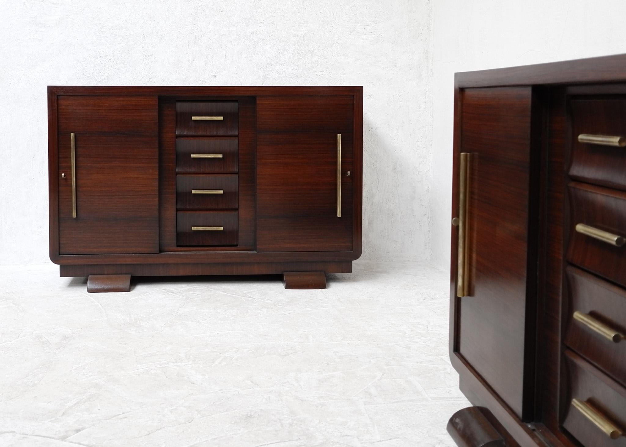A fine pair of French rosewood veneer art deco sideboards.

Extremely well made, the sideboards feature brass hardware to both the four central drawers and two lockable sliding doors.

The sideboards have been fully restored/Re-finished in our