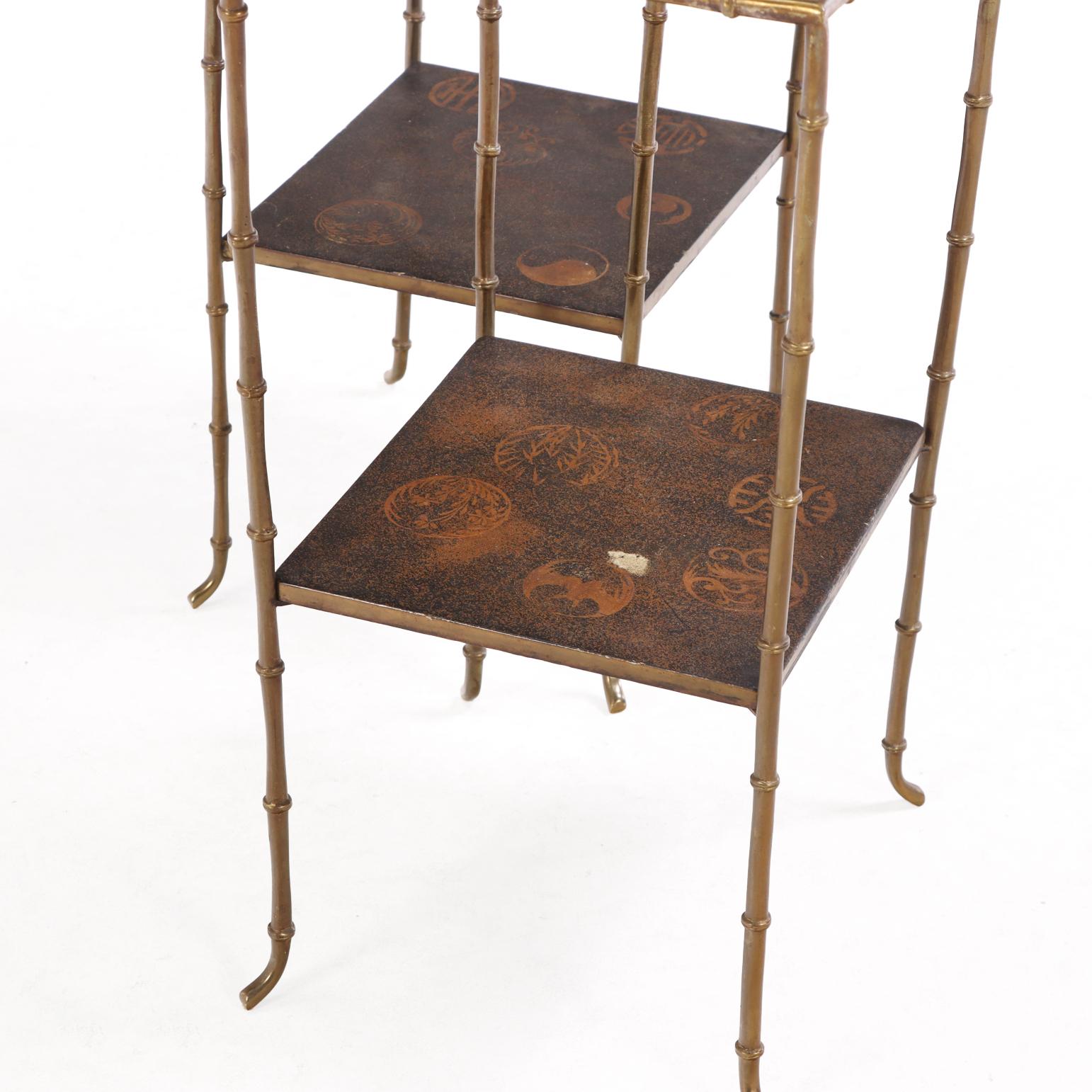 This petite pair of two-tier tables combines timeless elegance with subtle Asian influence. Each features bronze faux-bamboo legs and lacquered wood tops with delicate scenes of bamboo trees, a rooster, and other Asian motifs, offering a