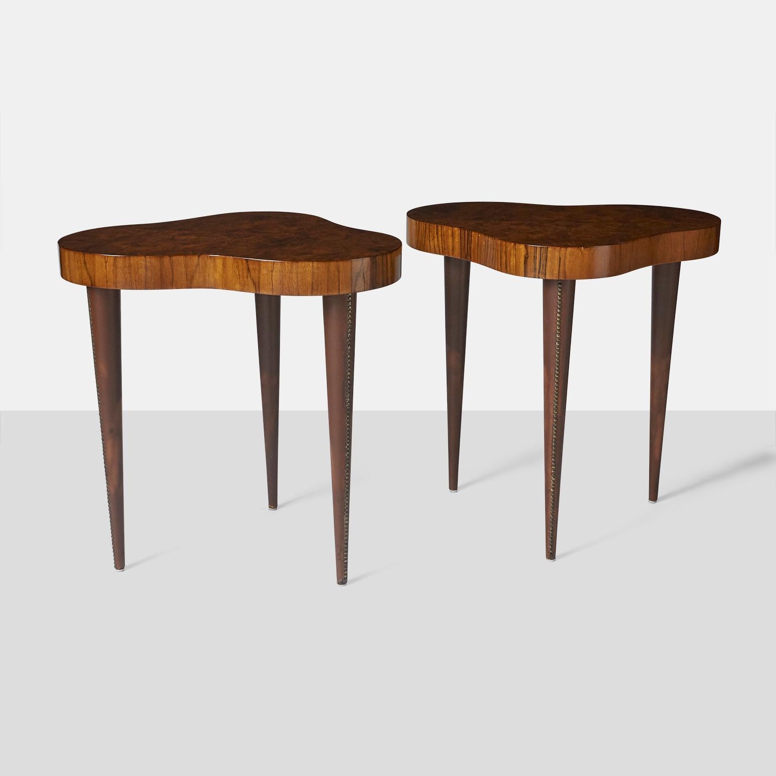 Paire de rares tables d'appoint Gilbert Rohde en bois de Paldao. Les pieds coniques sont recouverts de cuir et fixés par des clous en laiton. Etiquettes originales Herman Miller sur le dessous de chaque table.