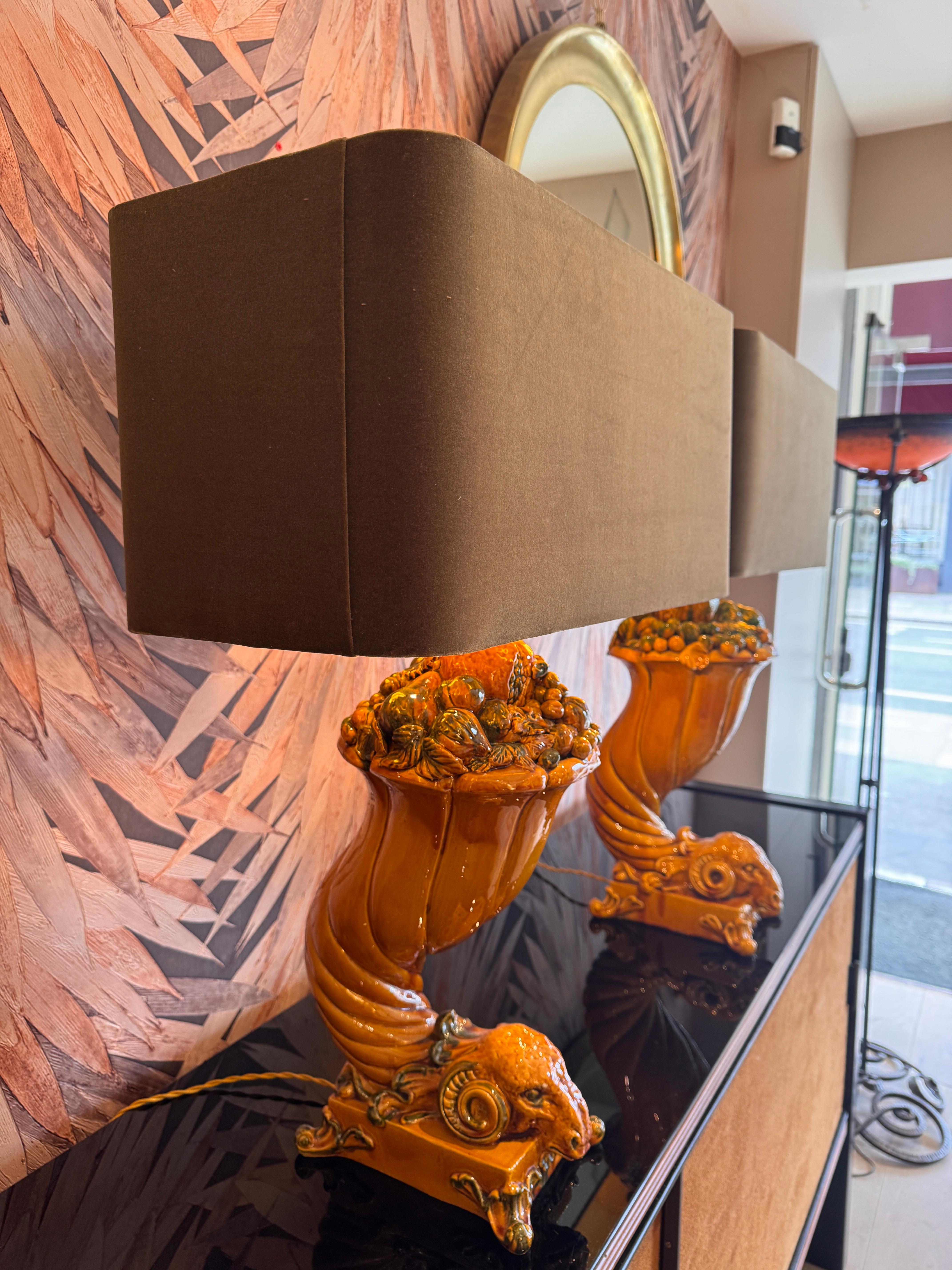 Raro par de lámparas de mesa muy decorativas, cada una de las cuales representa una cabeza de carnero inclinada con topiario de remates frutales . Un bello tono de color mostaza en toda la superficie con toques de verde .  (Opcional) También hay