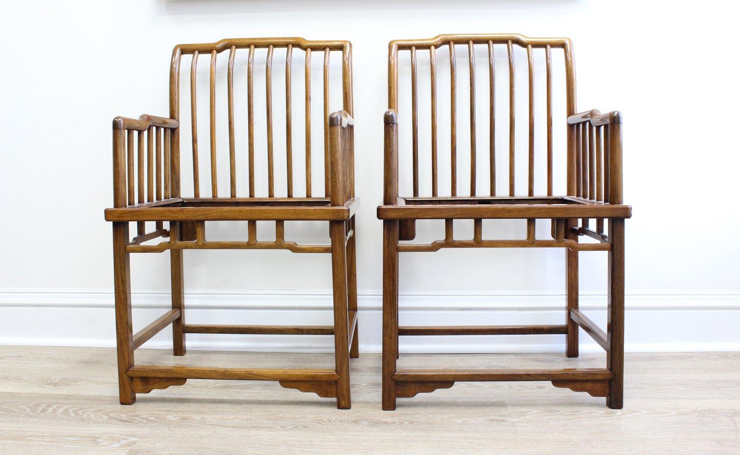 These elegantly formed chairs include arched, humpback top-rails supported on eight round posts extending to the back legs, with a matching series of five posts on either side bracing the arms. The arms step down and run parallel to the floor. 

The