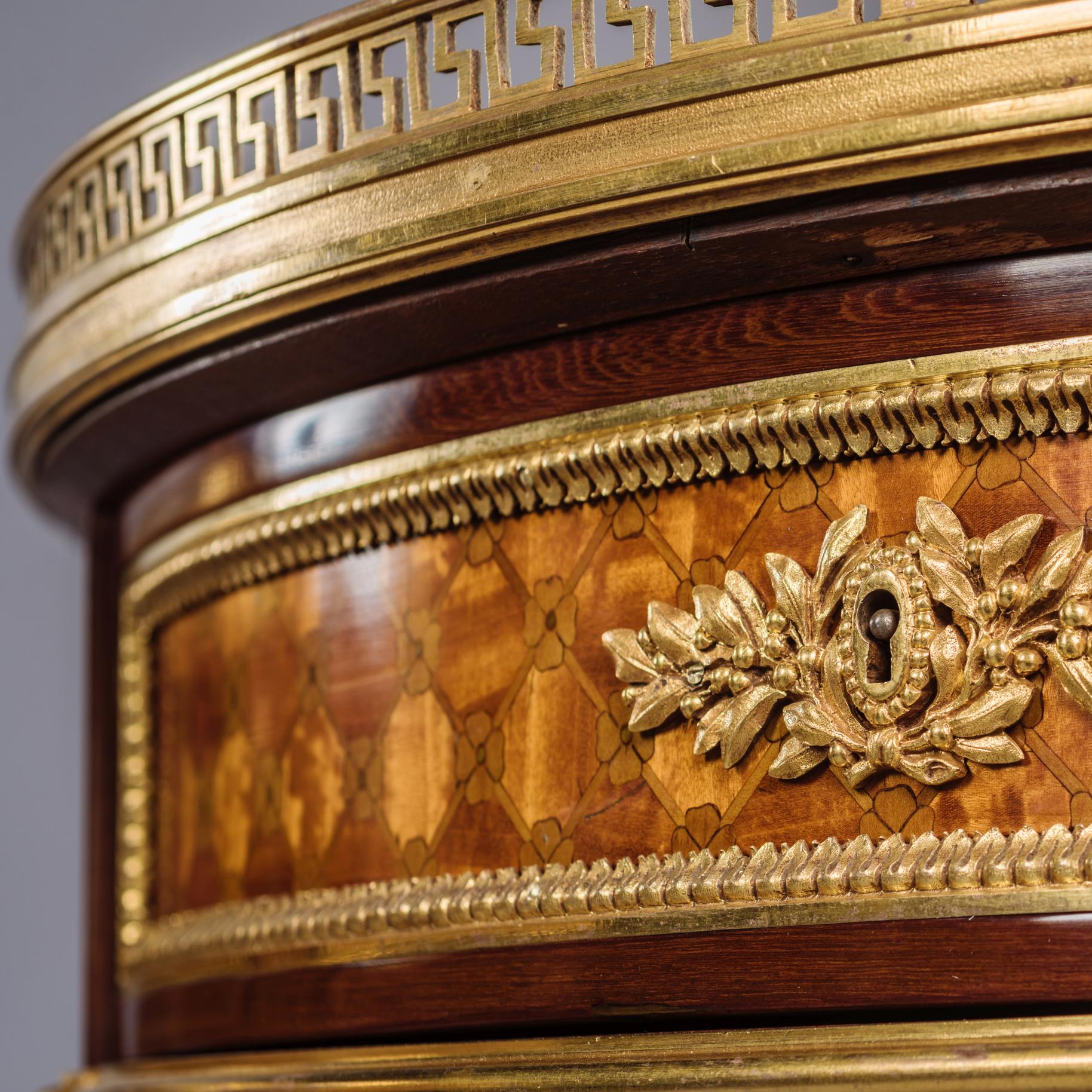Ein seltenes Paar von vergoldeten, in Bronze gefassten Parkett-Gueridons im Stil Louis XVI.

Jeder Tisch hat eine durchbrochene Galerie aus vergoldeter Bronze mit einer Platte aus grauem Marmor über einem Gitterfries aus Parkett, das eine