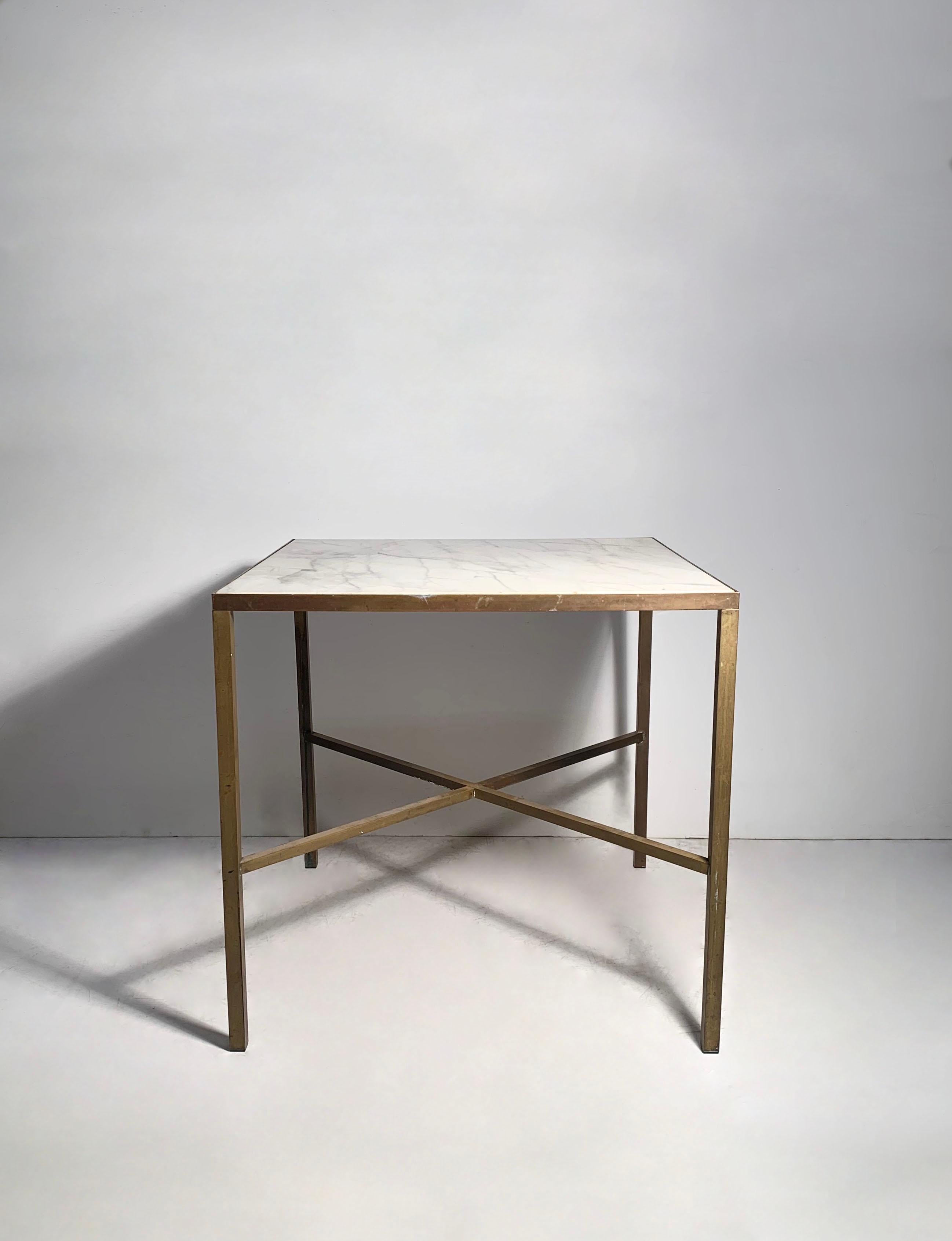 A rare architectural brass dinette table with X stretcher and a beautiful original marble top.  Attributed to Paul McCobb. Still researching to determine the exact model and line.  A very clever construction the way this was factory assembled,  No