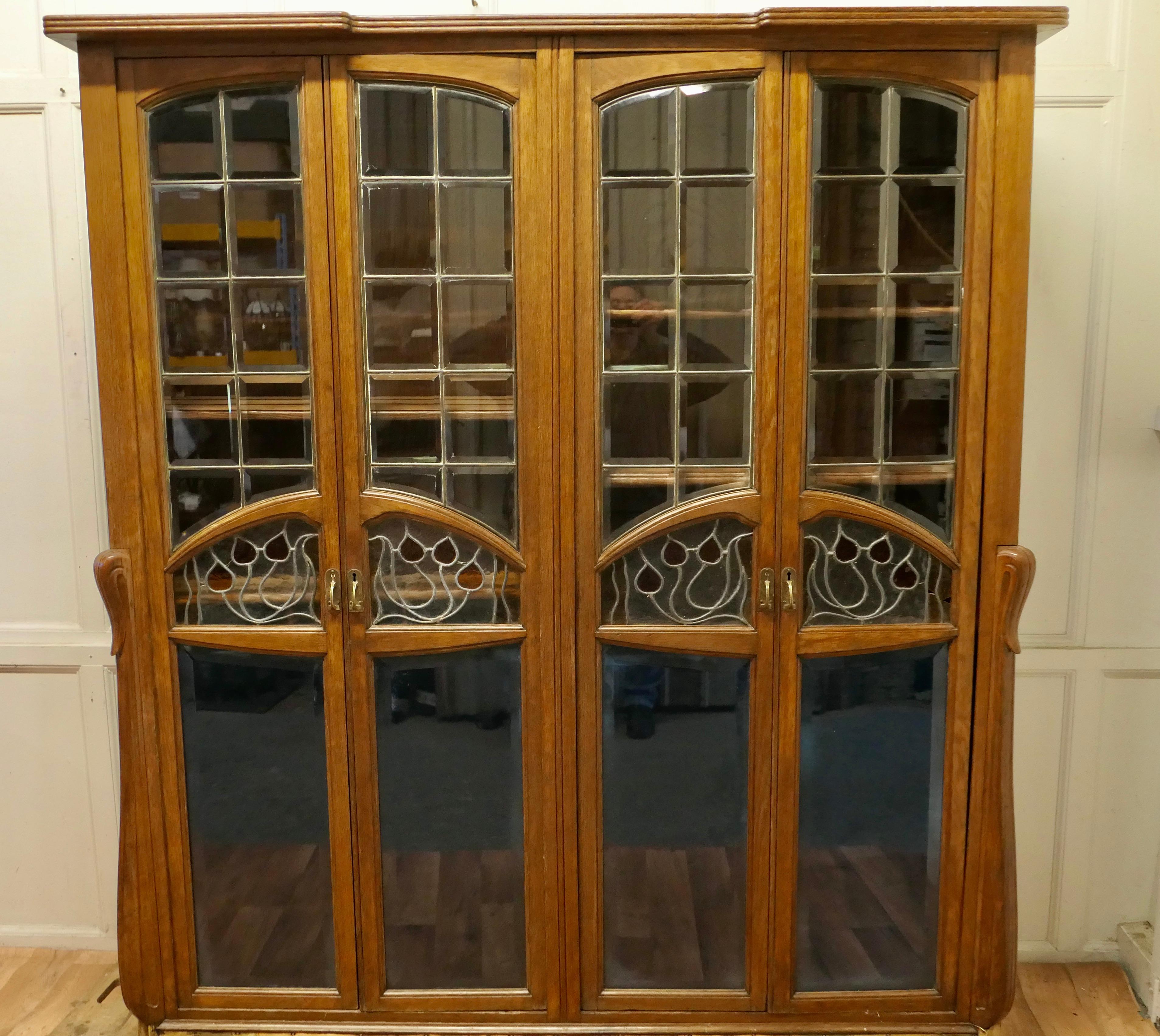 A Rare Piece of Progressive Arts and Crafts furniture, in golden oak and stained glass

This Large Bookcase has a remarkable and stylish design, typical of the late Victorian era associated with the Arts and Crafts movement. 
It is inspired in