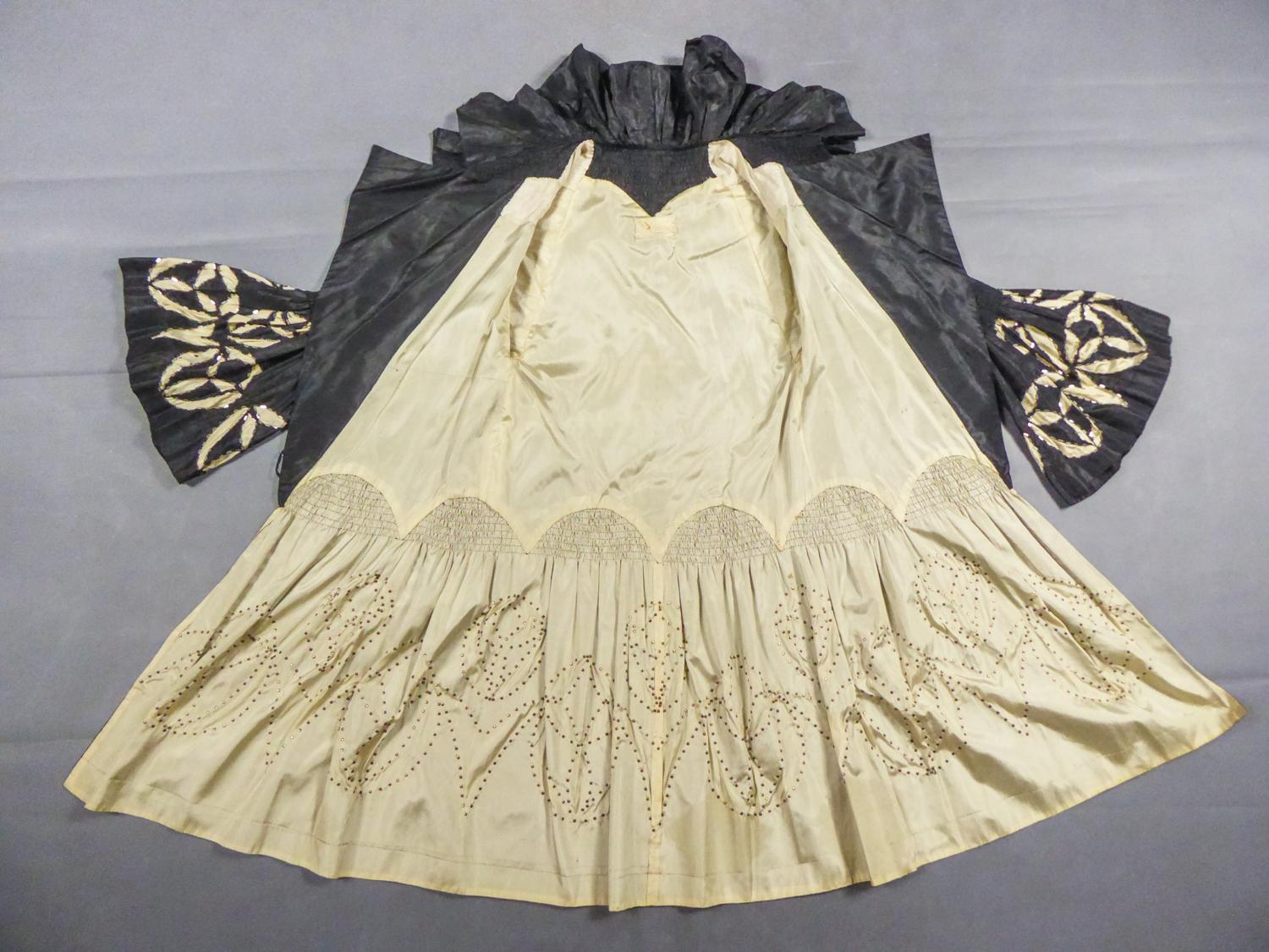 Circa 1925/1929

Paris or London

Dramatic opera coat in black silk taffeta and cream from the famous Maison de Couture Redfern, based in Paris, London and New York, dating from the late 1920s. Large cross-section cut (button missing) and large