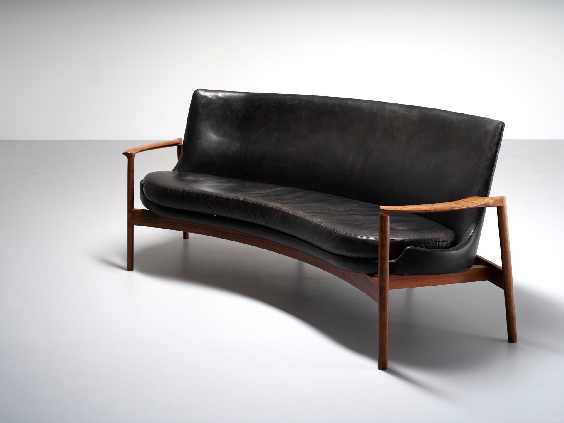 A seating group consisting of 2 easy chairs, a kidney shaped sofa and a matching coffee table. The set is designed by Ib Kofod-Larsen in 1974 for Fröscher in Germany. The seats are restored with new quality foam, while maintaining the original black