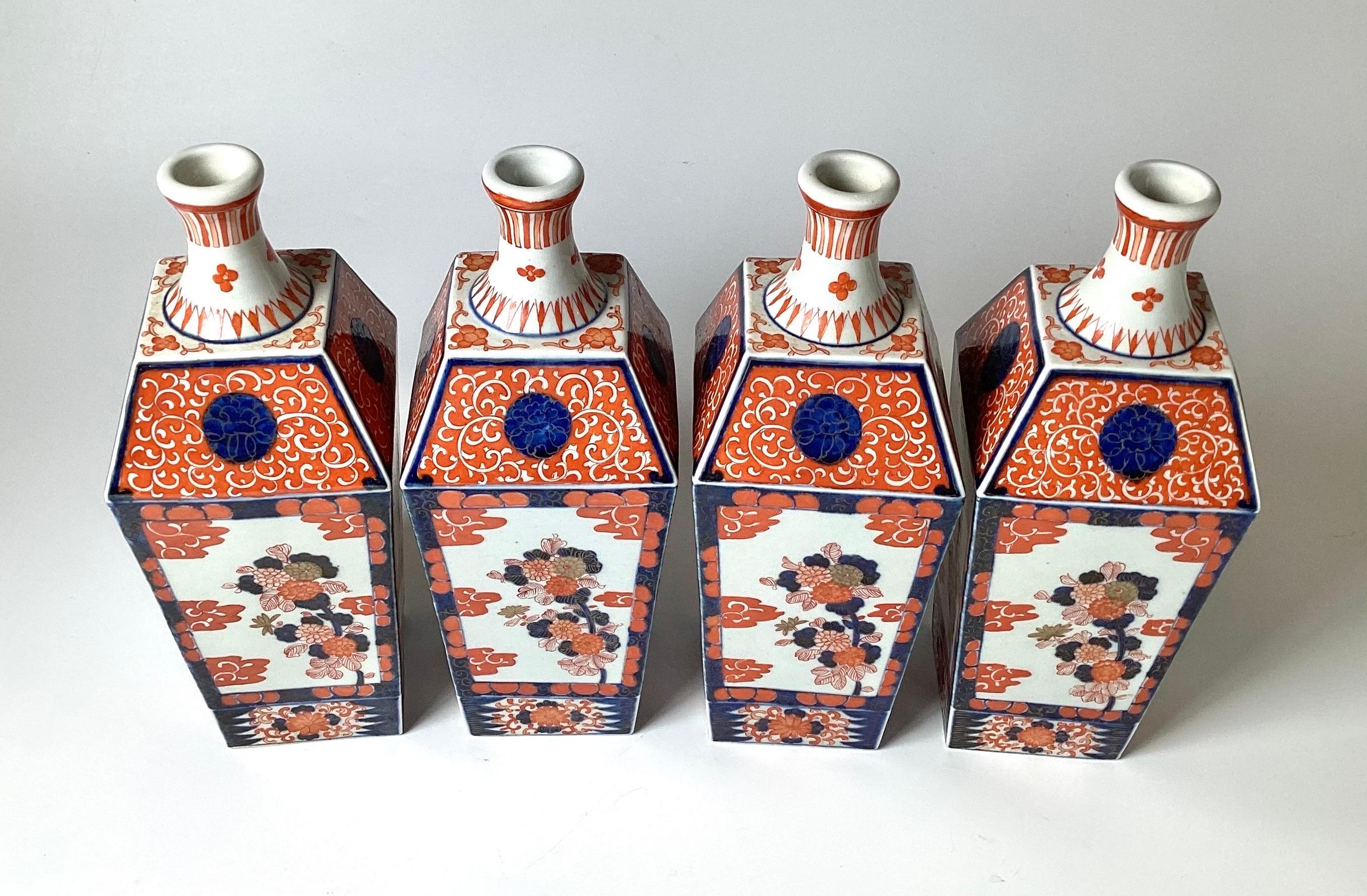 Ein seltener Satz von vier handbemalten japanischen Porzellanvasen in Form von Imari-Flaschen. Die Vasen haben eine quadratische, spitz zulaufende Form mit klassischem Imari-Dekor in Eisenrot und Kobaltblau auf weiß glasiertem Porzellan. Diese sind