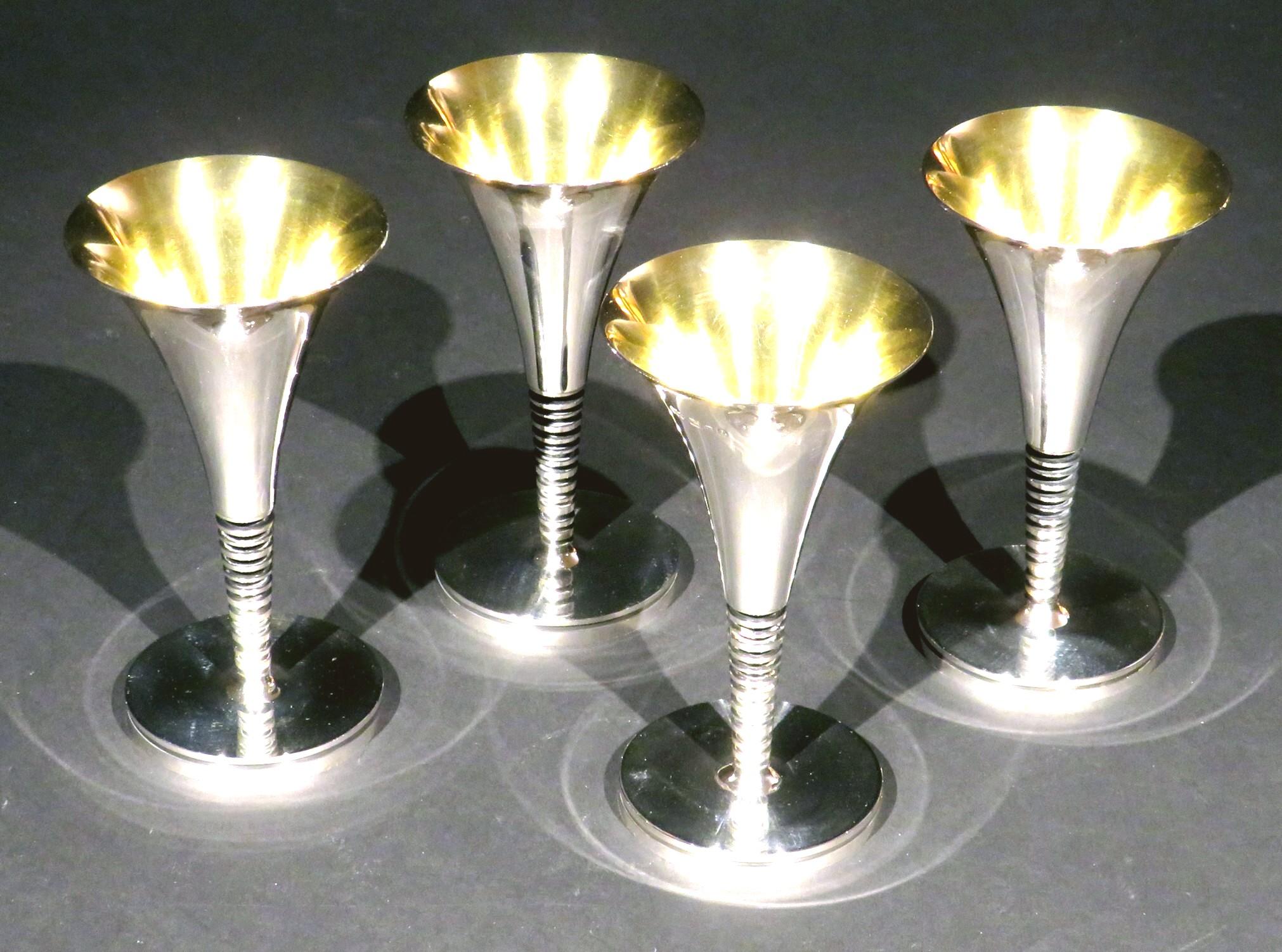 A truly rare & unique set of four stunningly handsome Post Modern sterling silver champagne flutes, specifically designed & made on commission by highly acclaimed British designer & silversmith Robert May. 
One pair was privately commissioned to