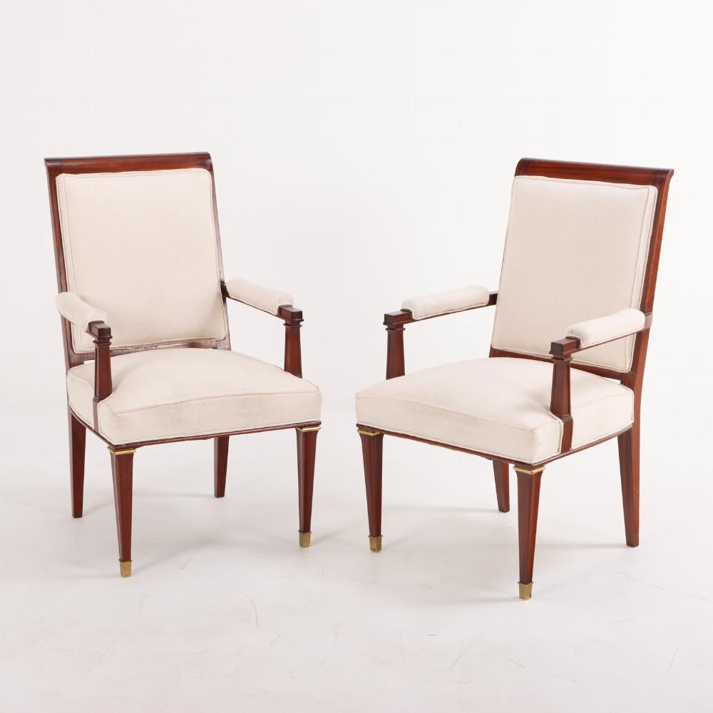 A rare set of sixteen French mahogany and giltwood dining chairs C 1940 in the manner of André Arbus (French, 1903-1969). The set consists of two armchairs and fourteen side chairs. These neo-classical style chairs were recently reupholstered and