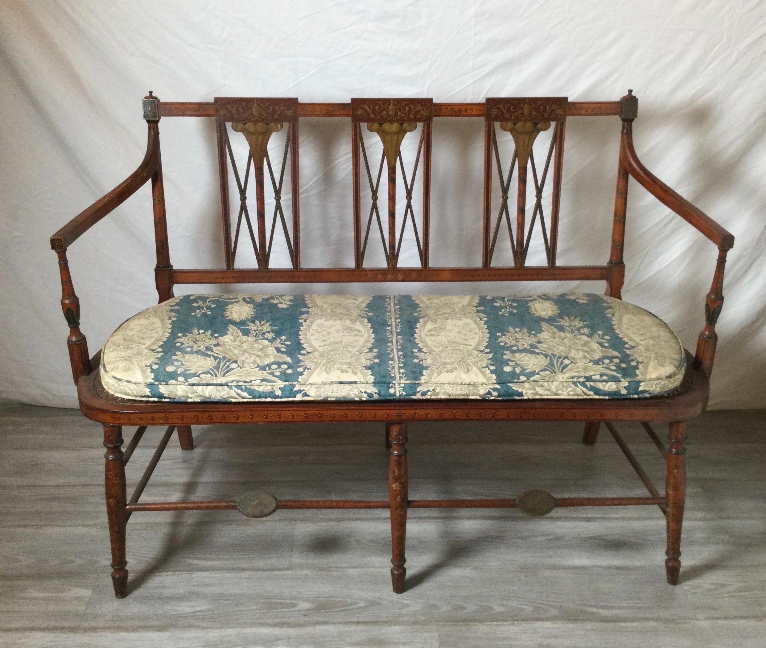 A rare Sheraton high style fancy painted settee. In the manner of Thomas Renshaw with intricate paint decoration with Tabaco leaf motif with a cane seat with damask cushion. Possibly the Virginia market. This is a Sothern folk art example.