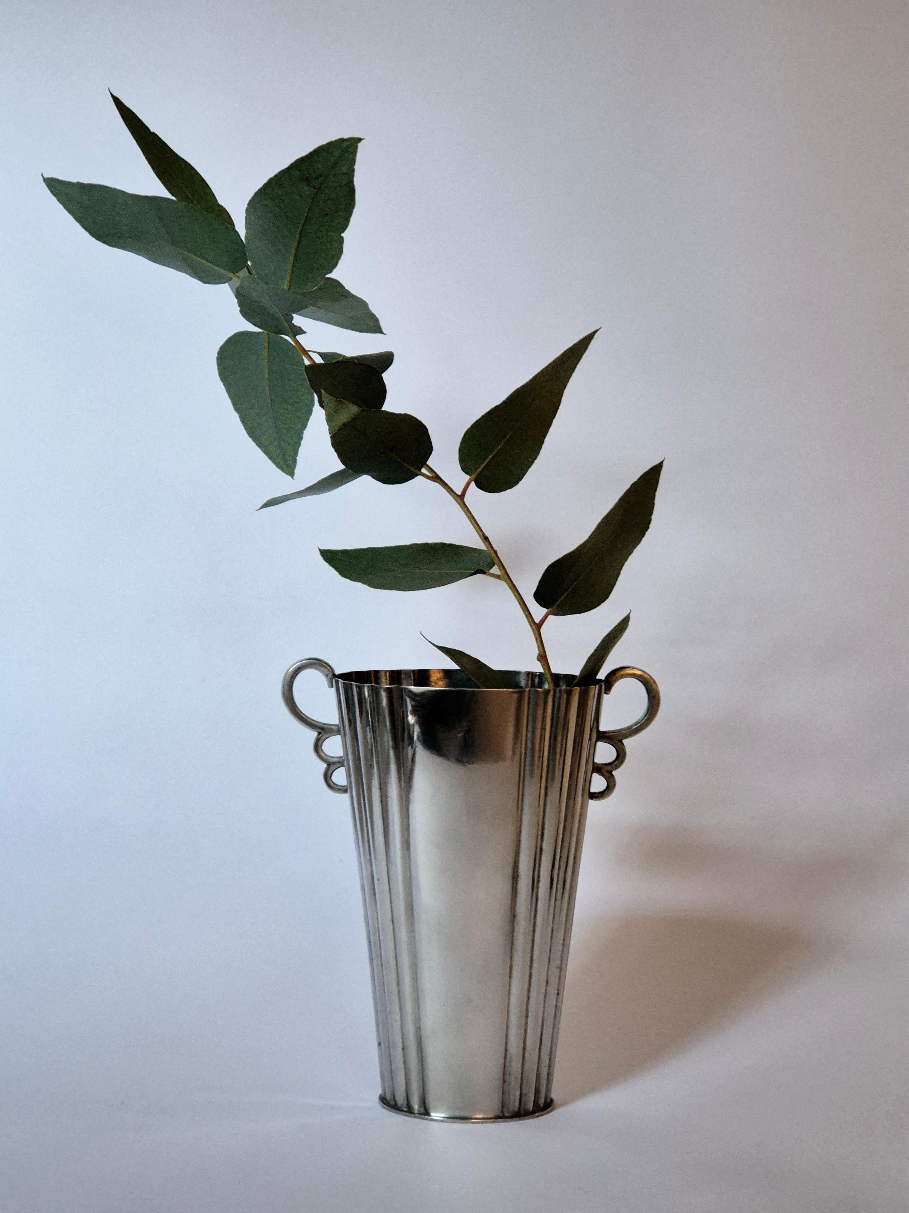 Vase aus Zinn mit schönen runden Henkeln, Swedish Grace / Art Deco von Sylvia Stave für CG Hallberg. 

Sylvia Stave und Estrid Ericson waren die beiden prominentesten Frauen im Zinndesign. Stave war künstlerischer Leiter bei CG Hallberg und in den