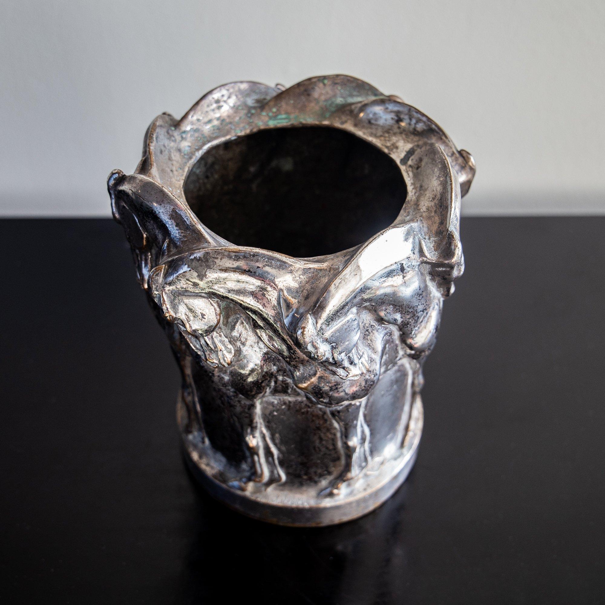 A silvered bronze vase with a frieze of prancing horses, bears incised monogram of French foundry Valsuani. Signed M Divani.

Marcello Valsuani emigrated from Italy to France and worked initially as technical director at the Hébrard foundry by 1902.