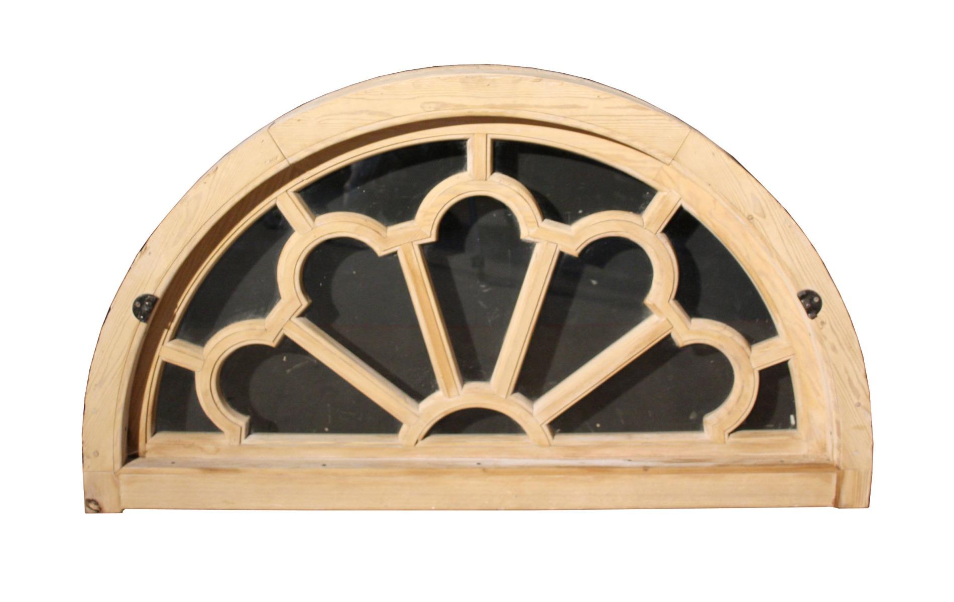 An antique fanlight constructed from pine. Glazed with clear glass and fitted within its original frame.