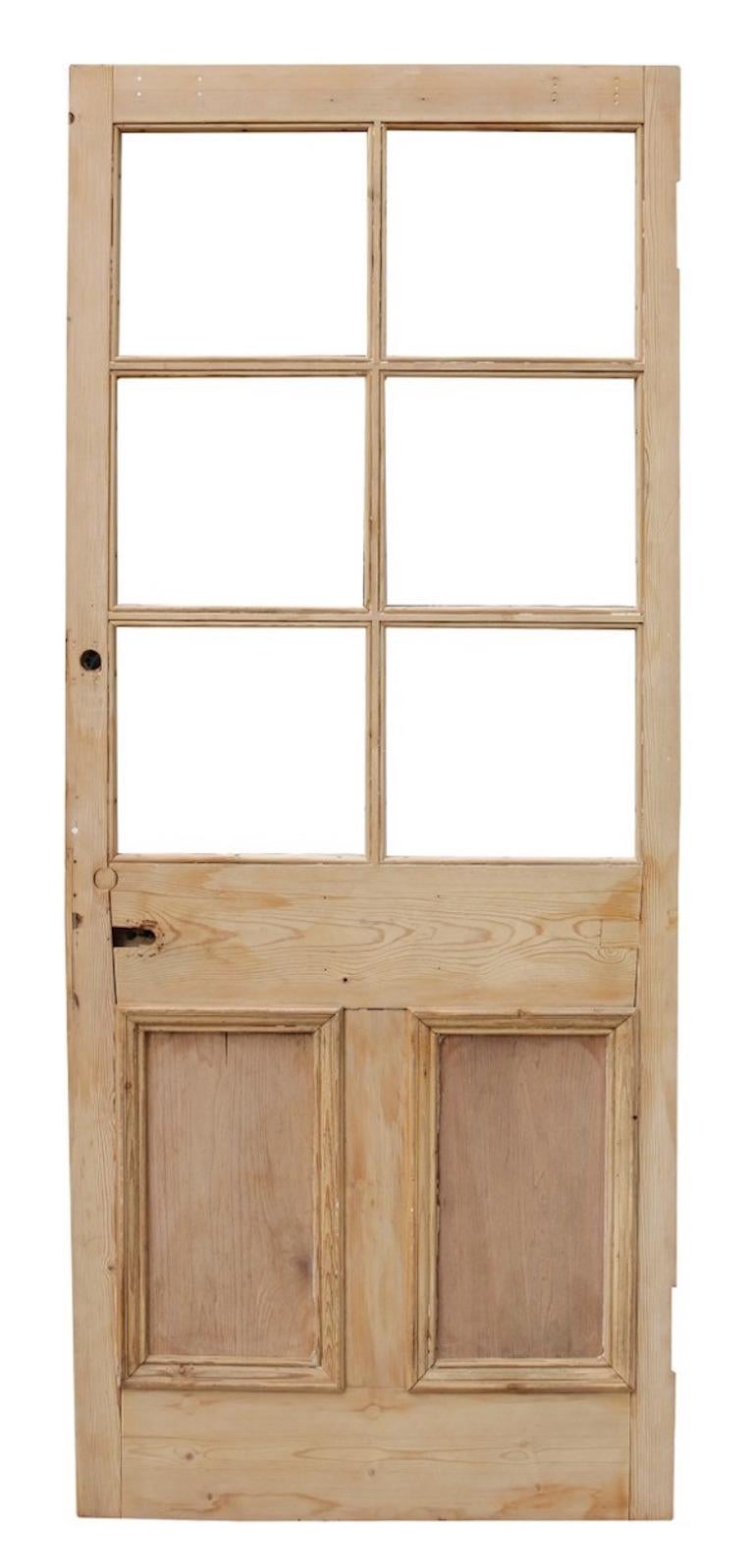 A reclaimed door constructed from pine, with space for six panes of glass.