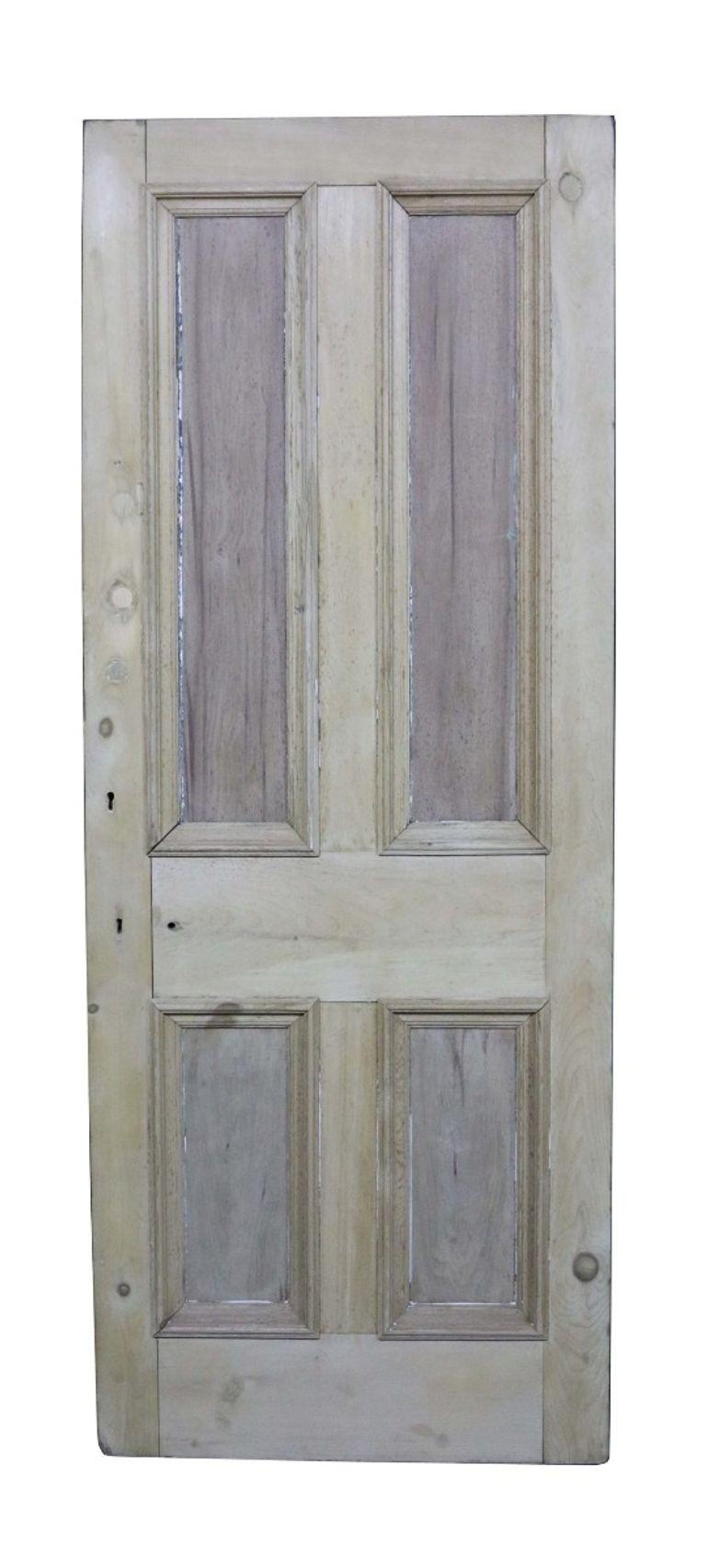 A salvaged exterior door constructed from pine in a four panel configuration.
