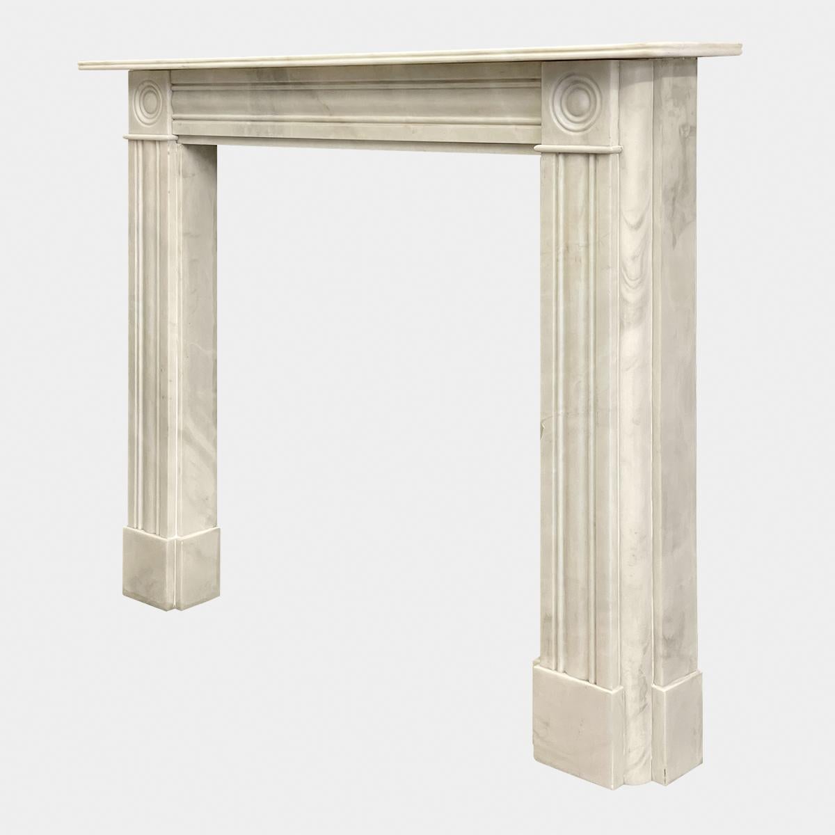 An English Regency style fireplace made in Rosa Aurora marble. Reclaimed from a Mayfair property in London. Typical early 19th century style with cushion mouldings to jambs and frieze, carved roundel corner blocks and a reeded shelf.
Images are a