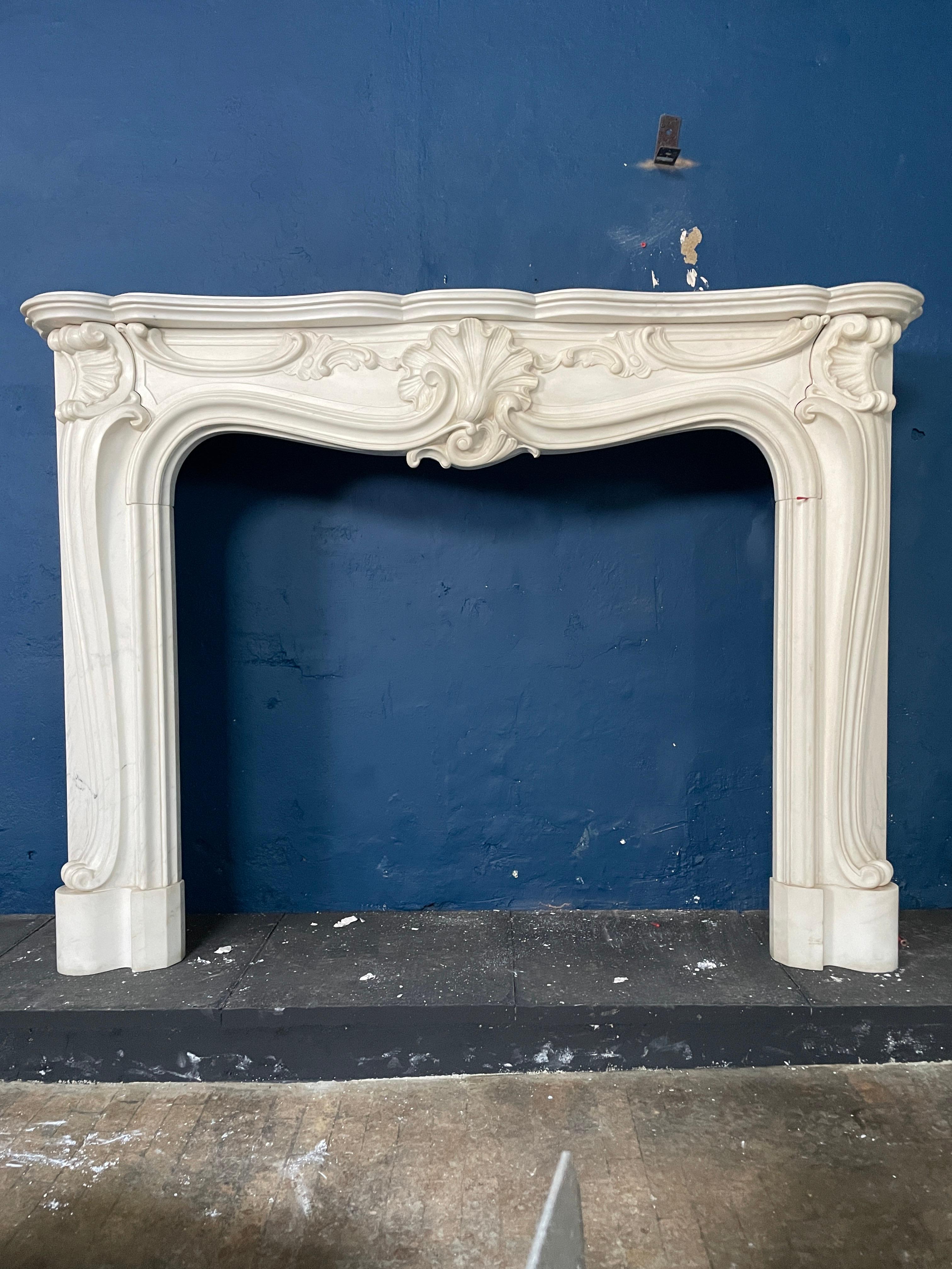 A large reclaimed Rococo style fireplace in white marble. Well carved and of good proportions, good quality white marble. Mid 18th century style 

Opening sizes 

102.5cm w x 90cm h 