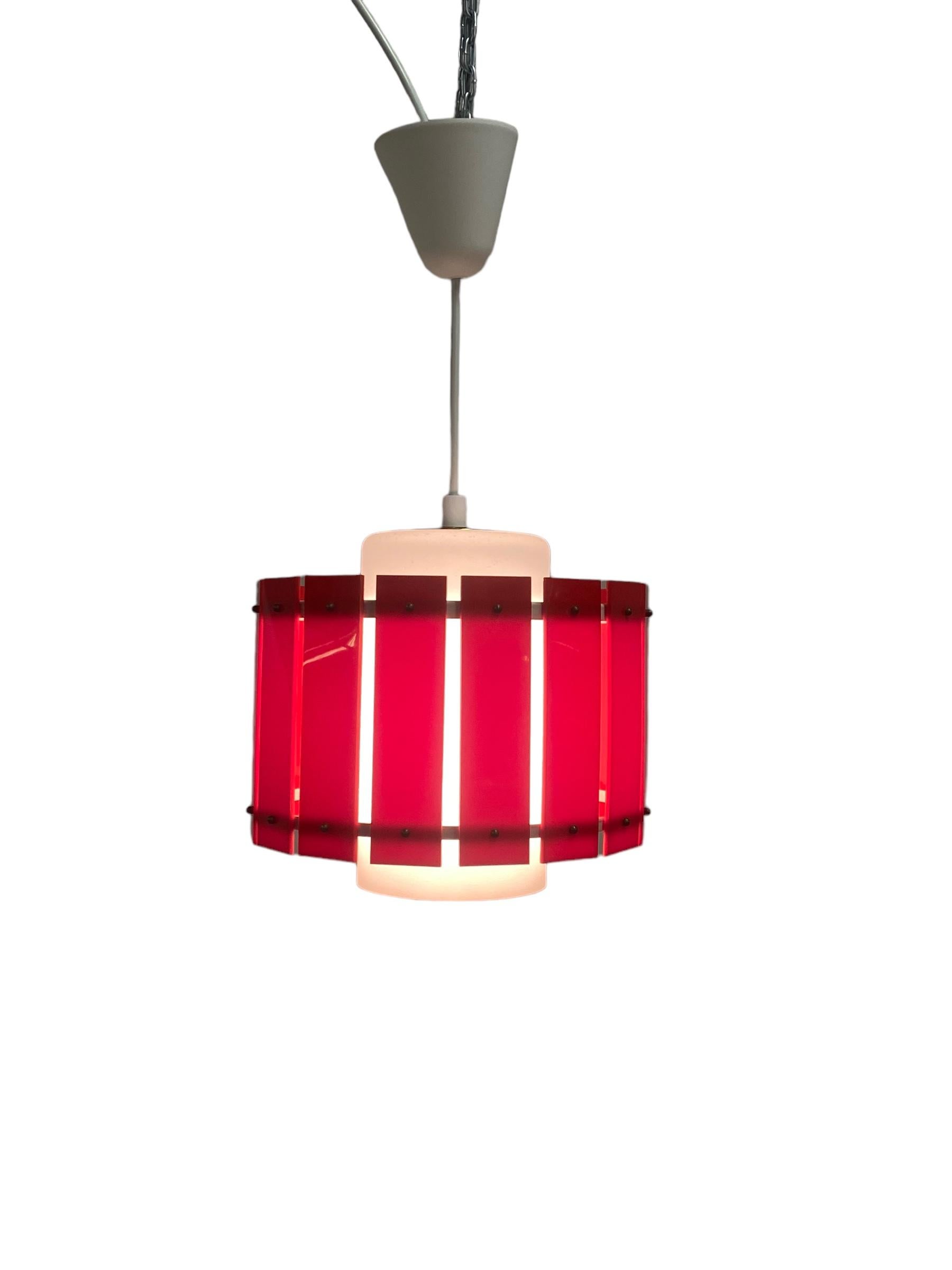 A cheerful and colourful ceiling pendant by Maria Lindeman for Idman. Already designed in the late 1950s and featured in the 1961 Idman catalogue, this lamp combines a frosted glass shade with a hard plastic outer shade that makes it all more