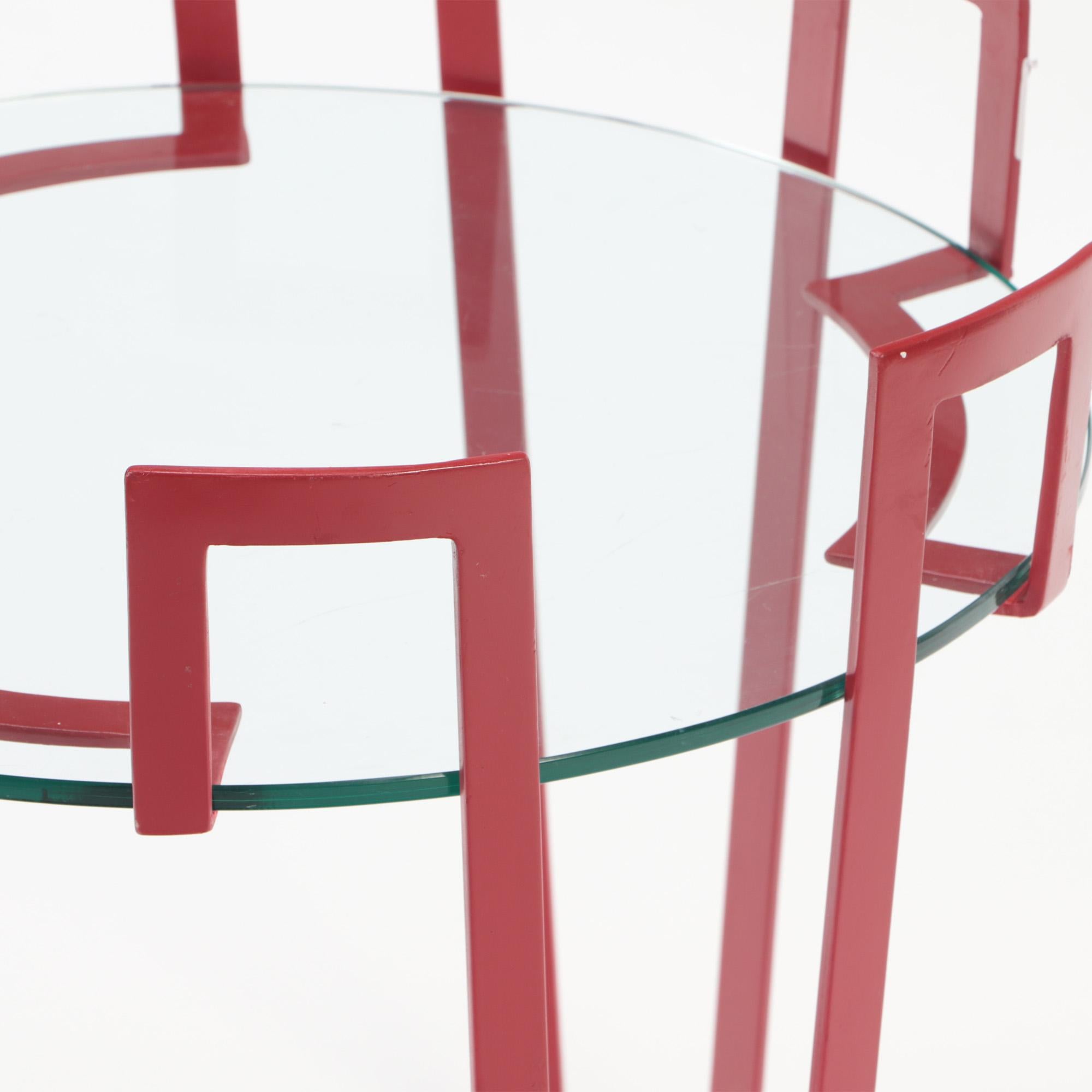 A red iron and glass end table . Contemporary. 1