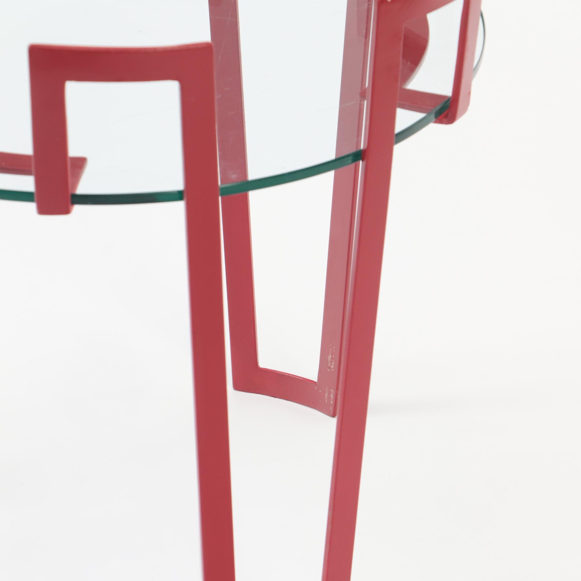 A red iron and glass end table . Contemporary. 2