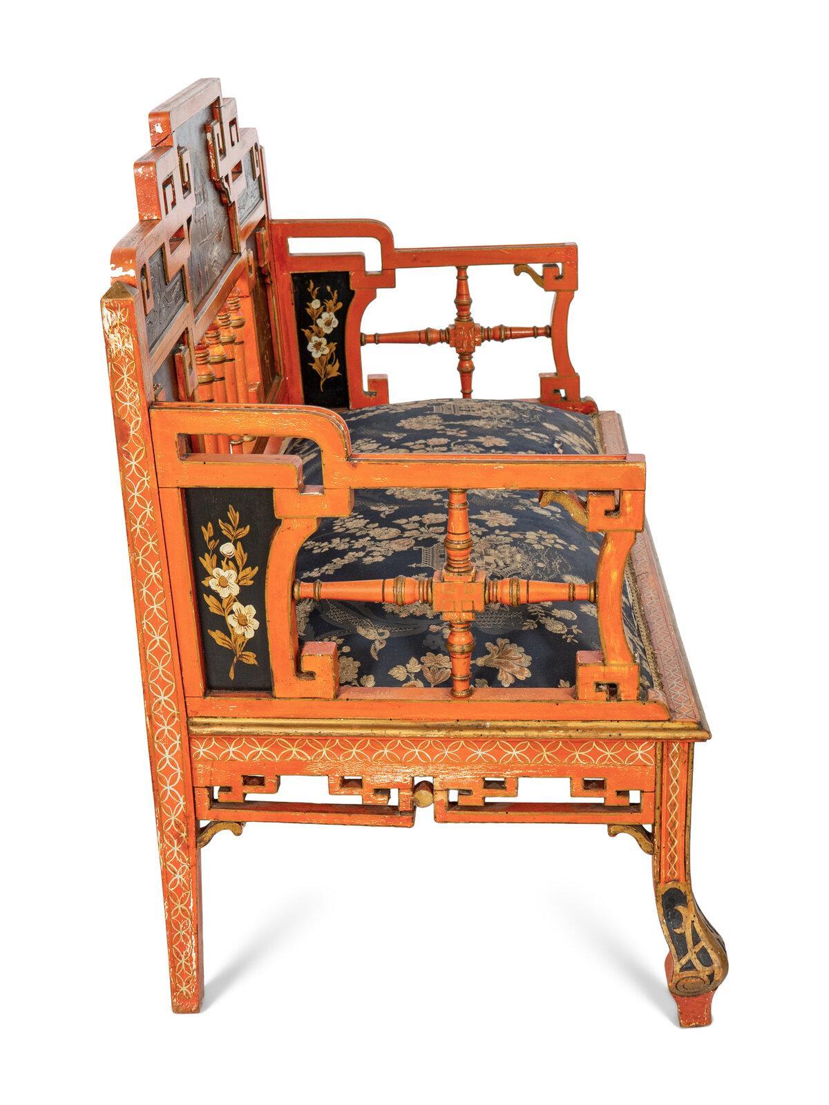 Questo incantevole divano a cineserie dipinto di rosso dei primi del Novecento mostra un'eccezionale maestria e dettagli artistici. I pannelli scenici dipinti a mano raffigurano paesaggi idilliaci, pagode e motivi floreali, tutti resi in una ricca