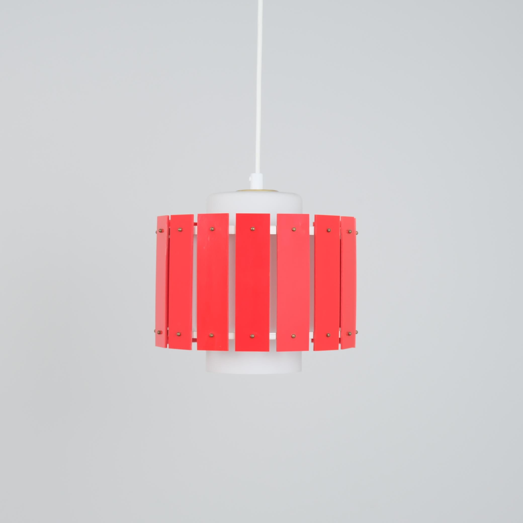 Un pendente da soffitto allegro e colorato di Maria Lindeman per Idman. Già disegnata alla fine degli anni '50 e presente nel catalogo Idman del 1961, questa lampada combina un paralume in vetro smerigliato con un paralume esterno in plastica dura