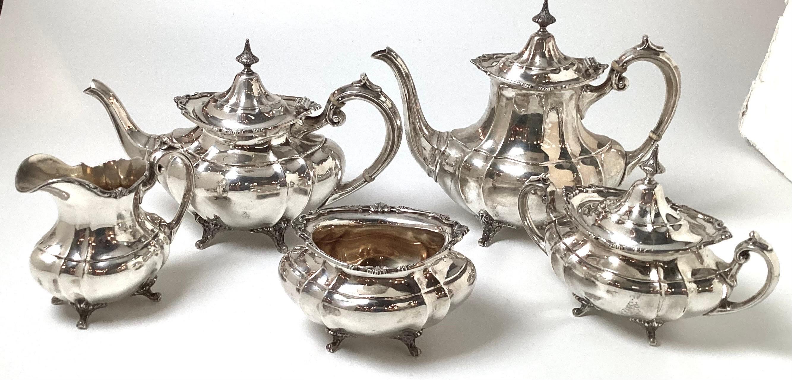 An Elegant pure sterling silver Hampton Court pattern 5 pc tea set by Reed and Barton.  The set consists of a coffee pot at 9 inches high, the teapot at 10 inches high, the covered sugar bowl at 8 inches high, the creamer 7.5 inches high and the