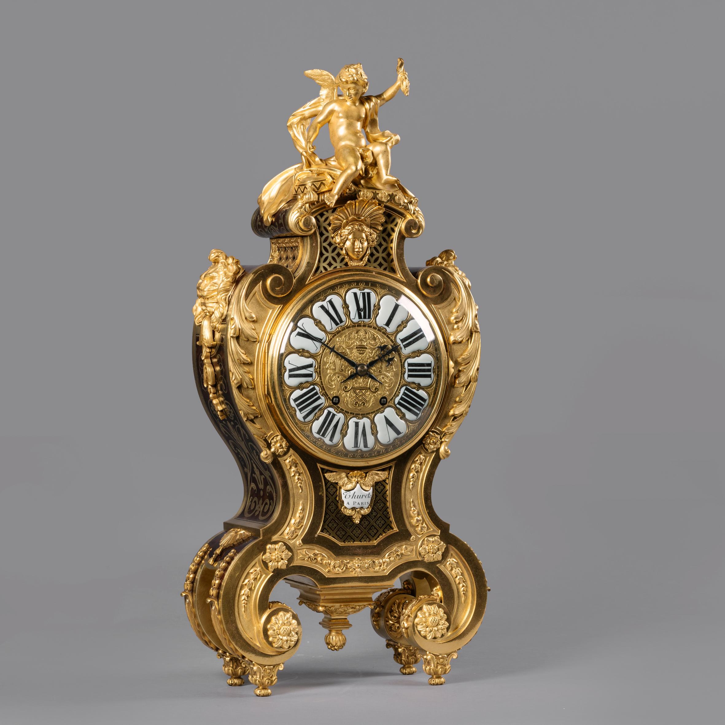 A Regence Style Gilt-Bronze and Boulle Marquetry Inlaid Grand Cartel de Applique, In the Manner of André-Charles Boulle.

The eight-day twin-train movement, striking on a bell.  

The dial with a porcelain cartouche inscribed ‘Thuret a Paris’.
The