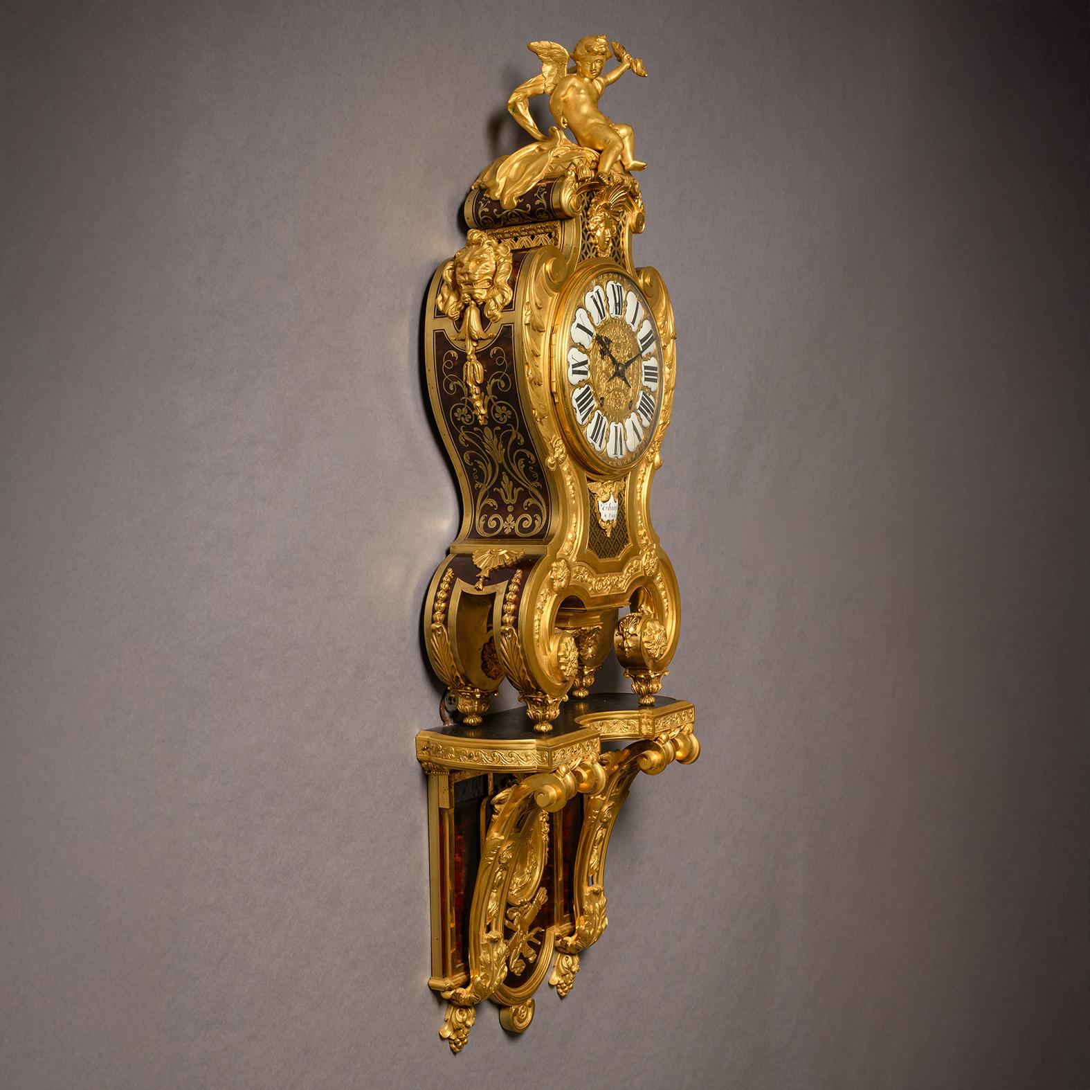 A Regence Style Gilt-Bronze and Boulle Marquetry Inlaid Grand Cartel de Applique, In the Manner of André-Charles Boulle.

The eight-day twin-train movement, striking on a bell.  

The dial with a porcelain cartouche inscribed ‘Thuret a Paris’.
The