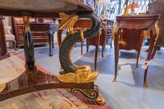 A  Regency  19th c centerhall table . Parcel gilt with a tripod dolphin base