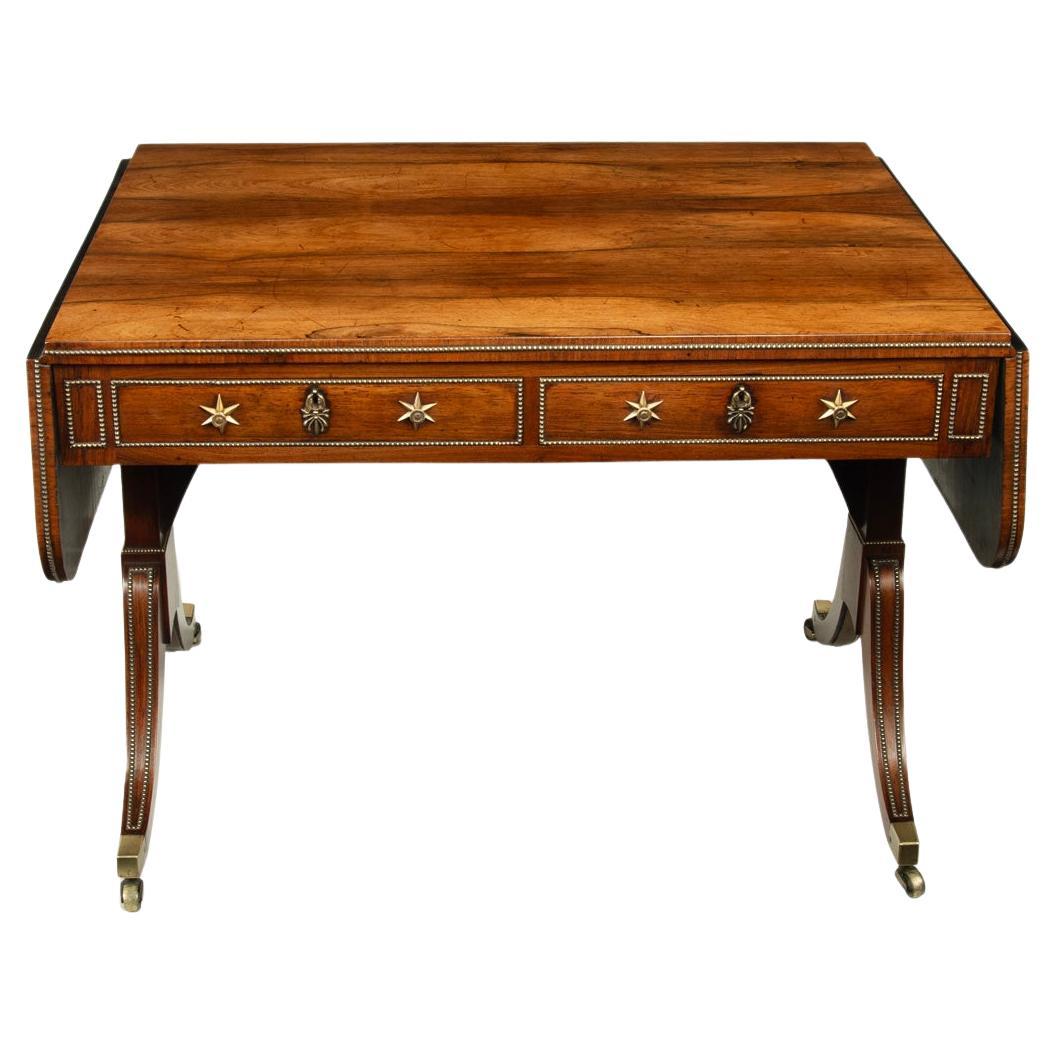 A Regency brass-inlaid rosewood sofa table attributed to Gillows