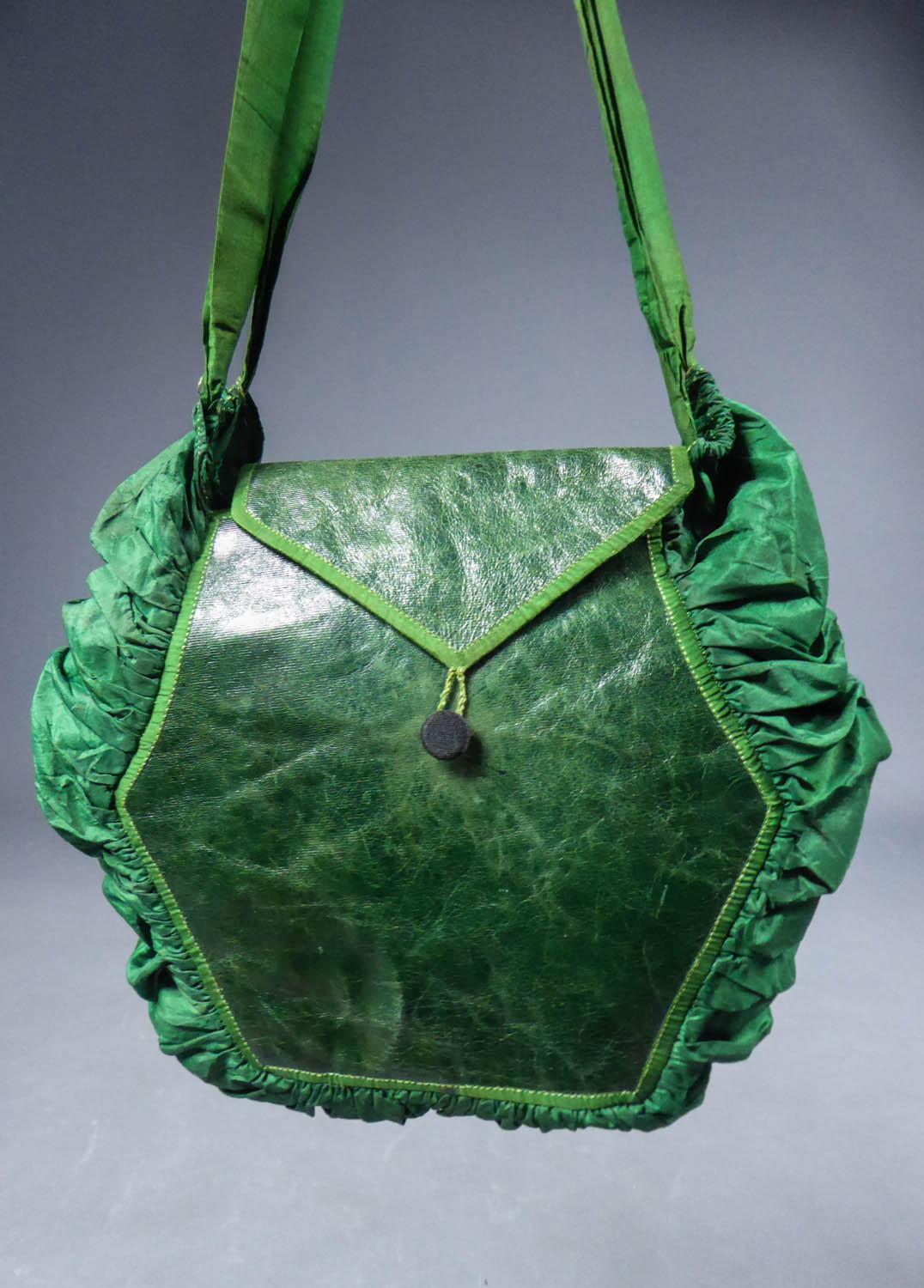 Circa 1810/1830
Europe

Elegant purse or reticule in green taffeta and leather lined with Indienne dating from the early 19th century. Balloon shape with wide pleated gusset in emerald taffeta and patinated and polish leather patches with piping in