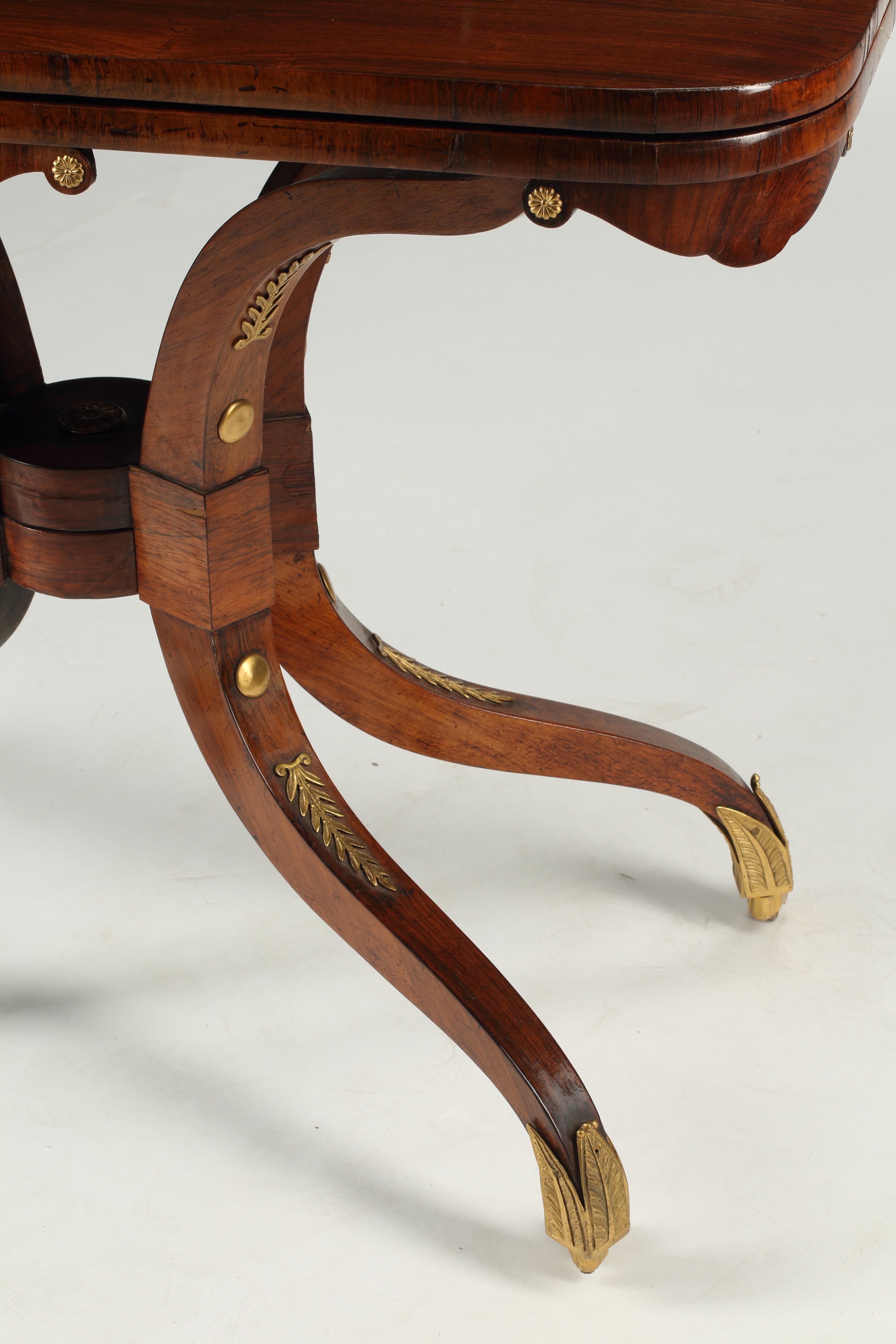 Ein eleganter englischer Palisander Regency Flip Top Games Table mit Dore Bronze Rosette montiert auf Schürze. Bronzebeschläge mit Lorbeermotiv auf Beinen, die mit Messingschuhen ausgestattet sind. Anfang des 19. Jahrhunderts.
Dieser vielseitige