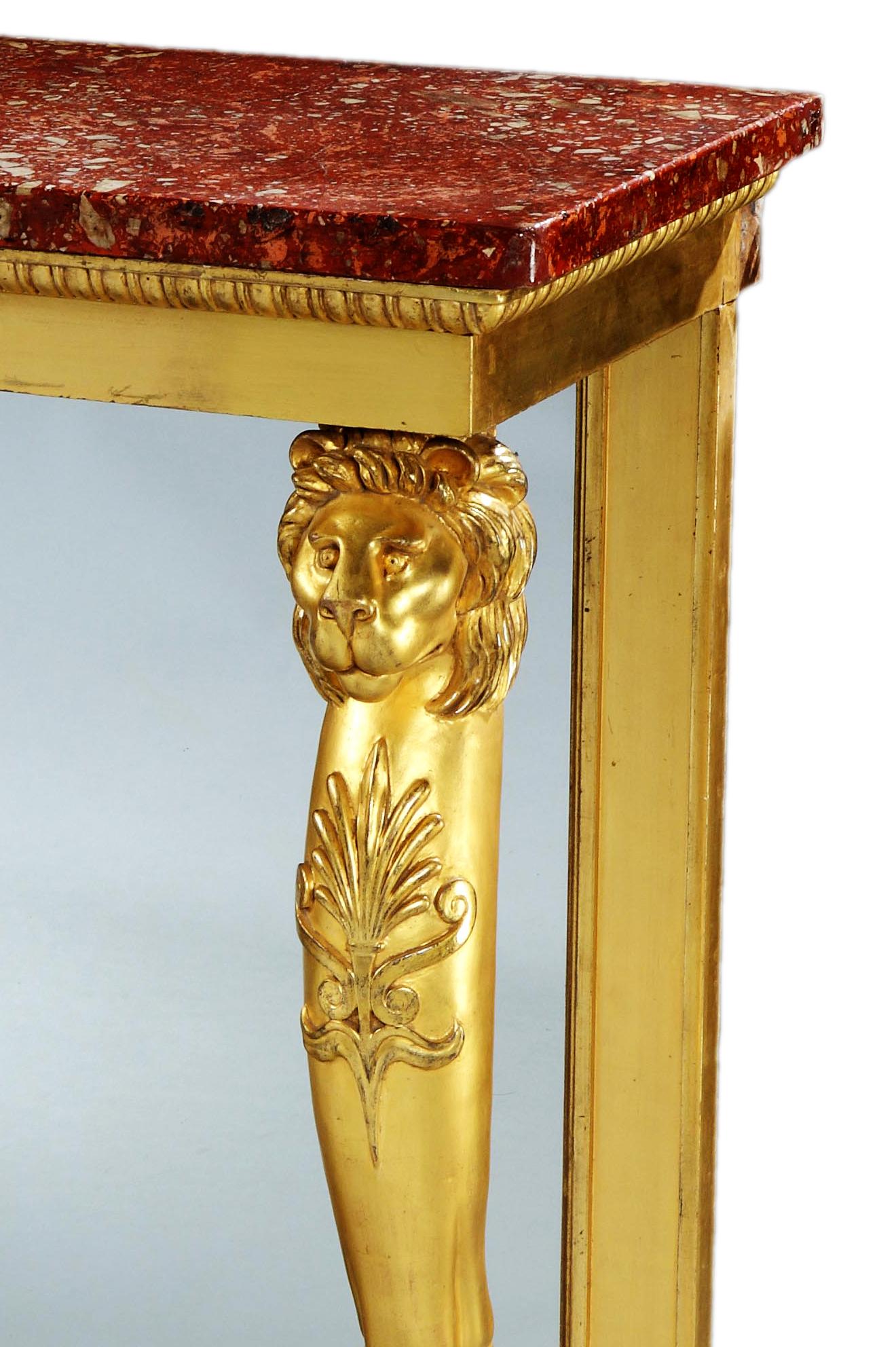 A fine Regency giltwood console table, with original red scagliola top, above an egg and dart frieze, resting on lions monopodia legs terminating in paw feet, on a faux marble plate-form base.