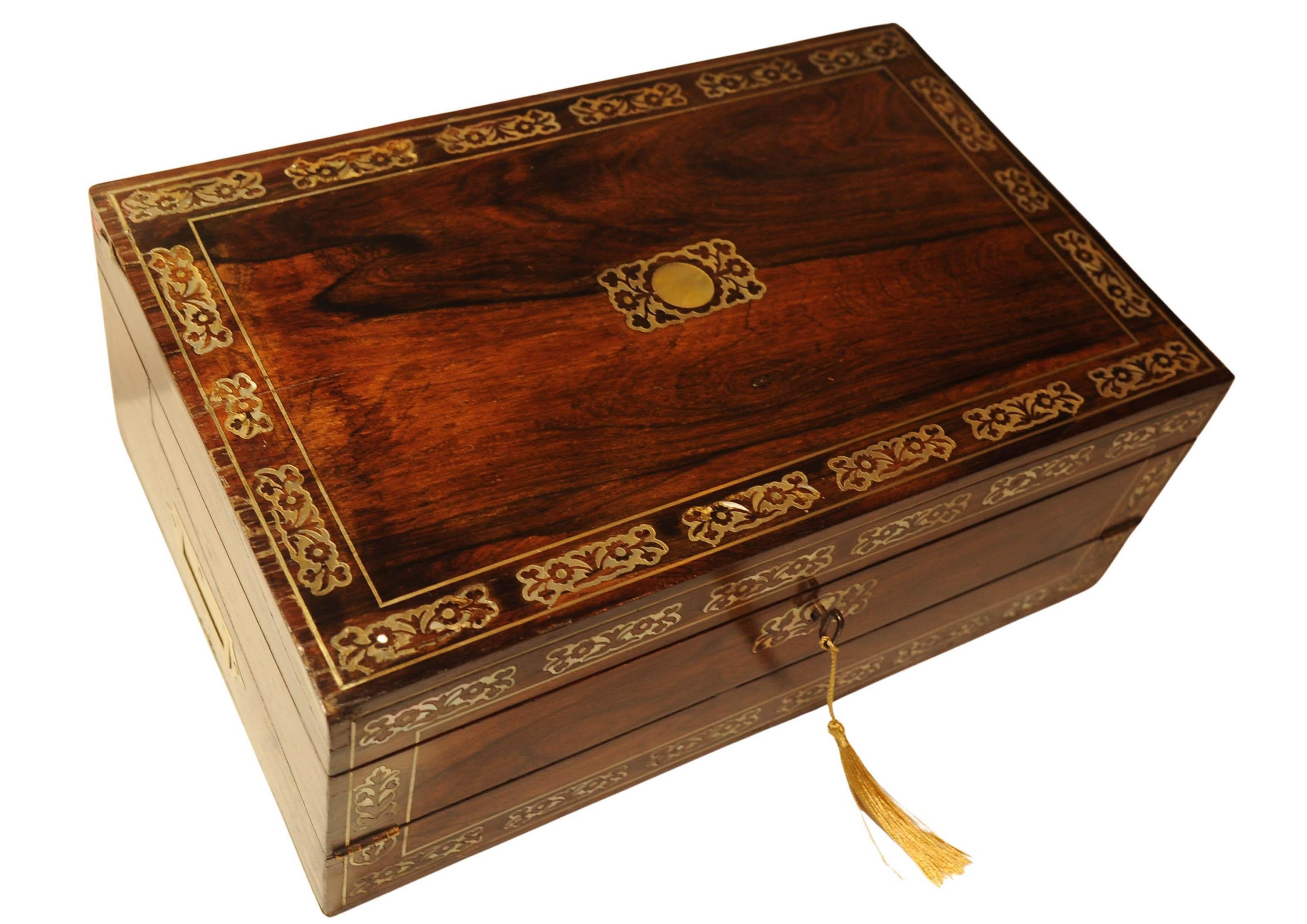 Un Impresionante Pendiente de Escritura Artesanal de Palo de Rosa de la Época de la Regencia. 
Con interior de terciopelo morado, equipado con los tinteros cuadrados originales de latón.

Está decorada con hermosas incrustaciones florales y tiene