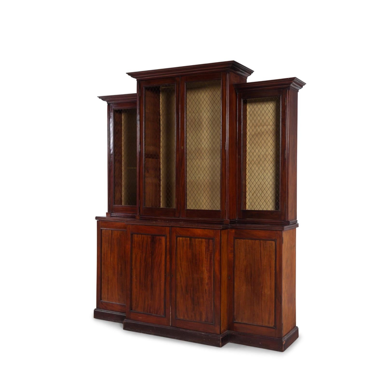 A Regency Mahogany Breakfront Bookcase
19th Century, Grilled Upper Doors With Lower Doors Concealing Shelves.  Nice Color And Patination.
Height 89 x width 77 x depth 21 inches.