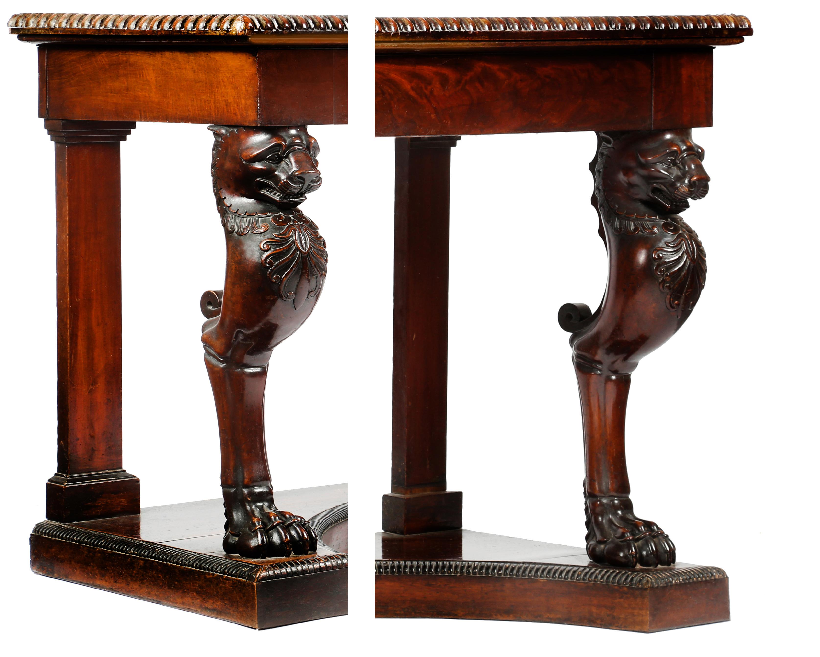 A Regency mahogany console table

The rectangular top with a beaded edge, above a figured rich veneered frieze, resting on very well carved lion's monopodia legs, on a concave platform base.