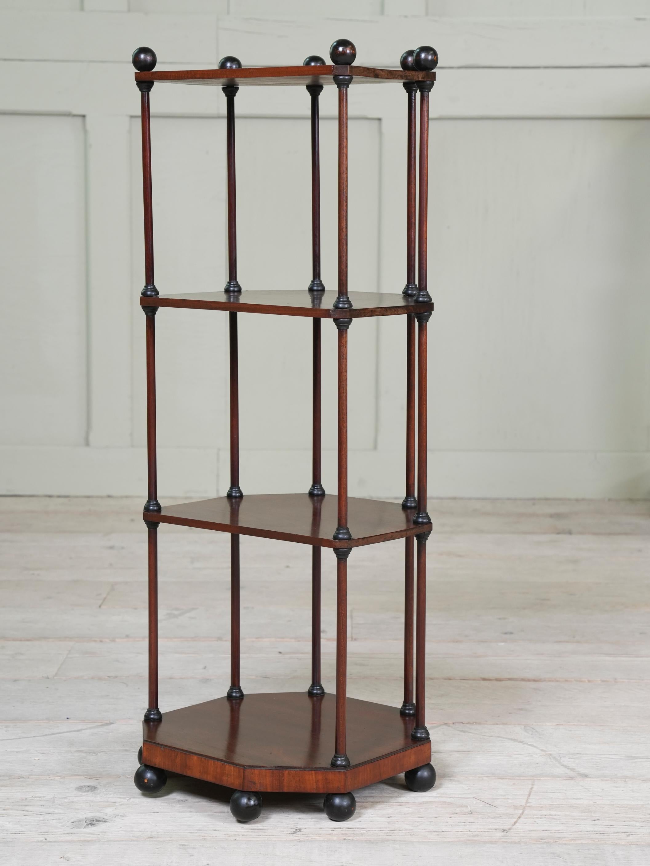 The four tier mahogany shelves joined by delicate columns terminating in ebonised ball finial and feet.